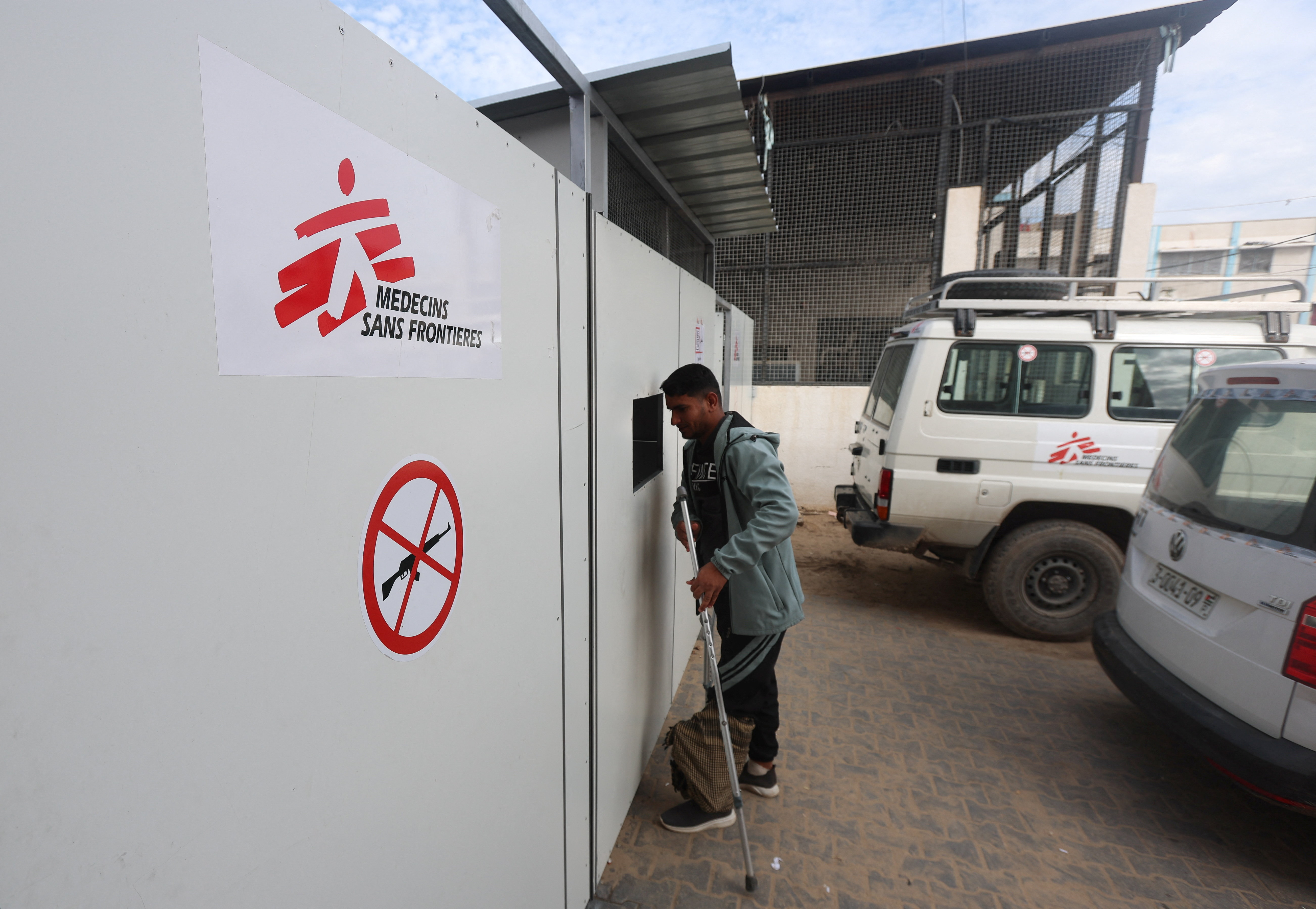 A Palestinian war-wounded man waits at the entrance, hoping to receive medical treatment, at a clinic run by medical charity Medecins Sans Frontieres (MSF), amid shortages of medical supplies, in Khan Younis, southern Gaza Strip, December 31, 2025. REUTERS/Ramadan Abed