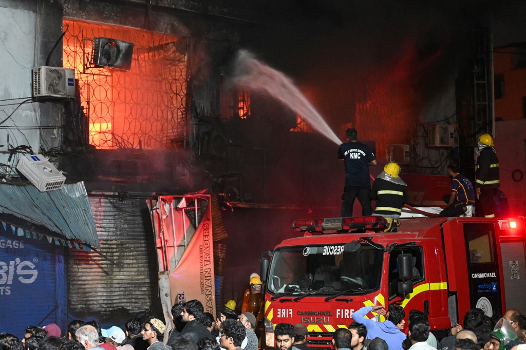 Firefighters douse a fire that broke out at a shopping mall in Karachi on January 18, 2026. (Photo by Rizwan TABASSUM / AFP)