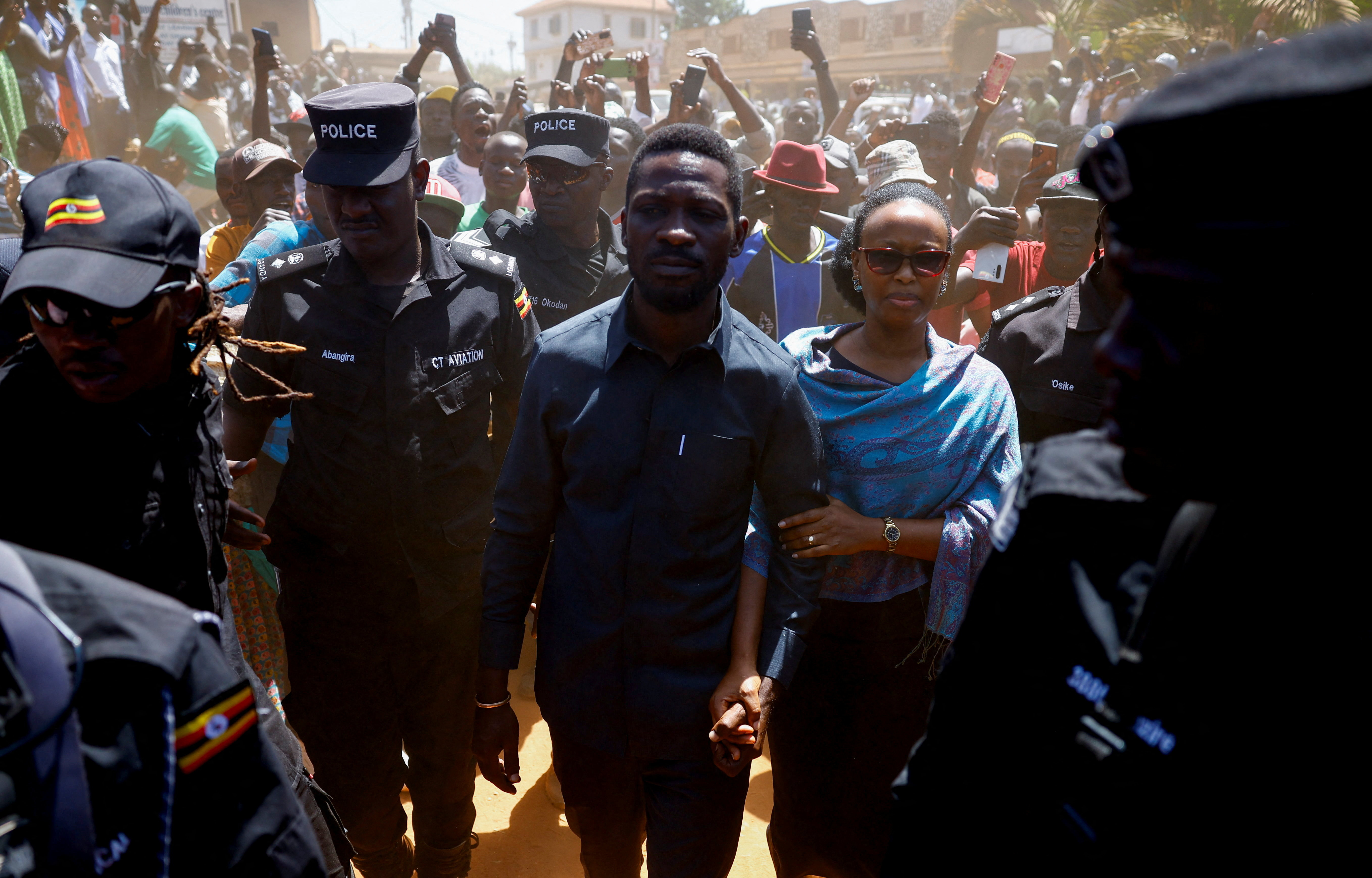 Bibi Wine and his wife are escorted by police and supporters as they arrive to vote.