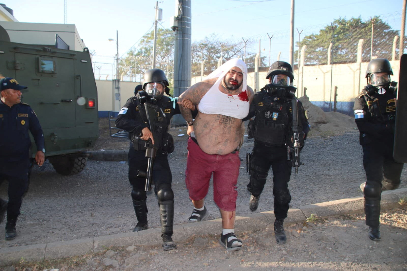 Law enforcement officers escort the leader of the Guatemala branch of Barrio 18 (M-18) gang Aldo Dupie Ochoa Mejia, alias "El Lobo", following security forces regaining control of the Renovacion 1 prison where inmates rioted and took hostages to demand greater privileges for a gang leader, in a location given as Escuintla, Guatemala, in this handout image released on January 18, 2026. National Civil Police/Handout via REUTERS THIS IMAGE HAS BEEN SUPPLIED BY A THIRD PARTY. NO RESALES. NO ARCHIVES. MANDATORY CREDIT.