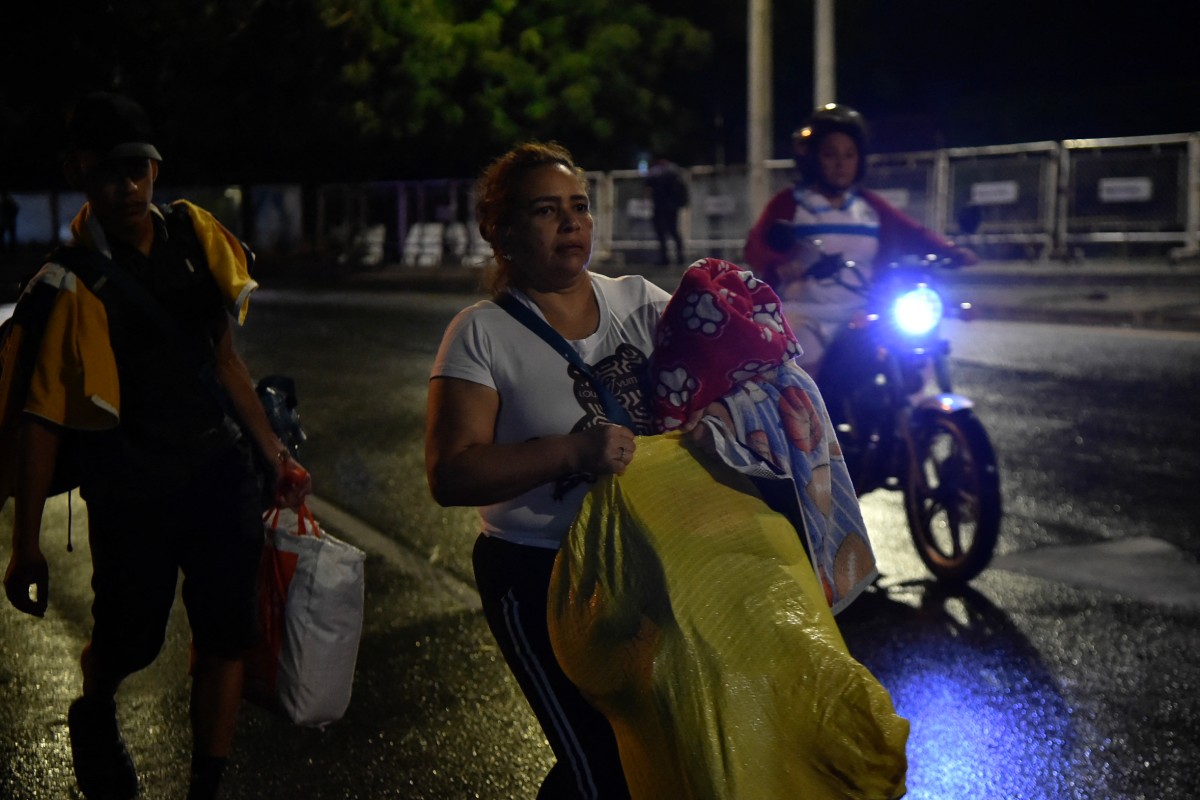 Venezuelans leaving their country arrive at the border crossing in Cucuta, Colombia, on January 3, 2026, after US forces had captured Venezuelan leader Nicolas Maduro after launching a "large scale strike" on the South American country. (Photo by Schneyder Mendoza / AFP)