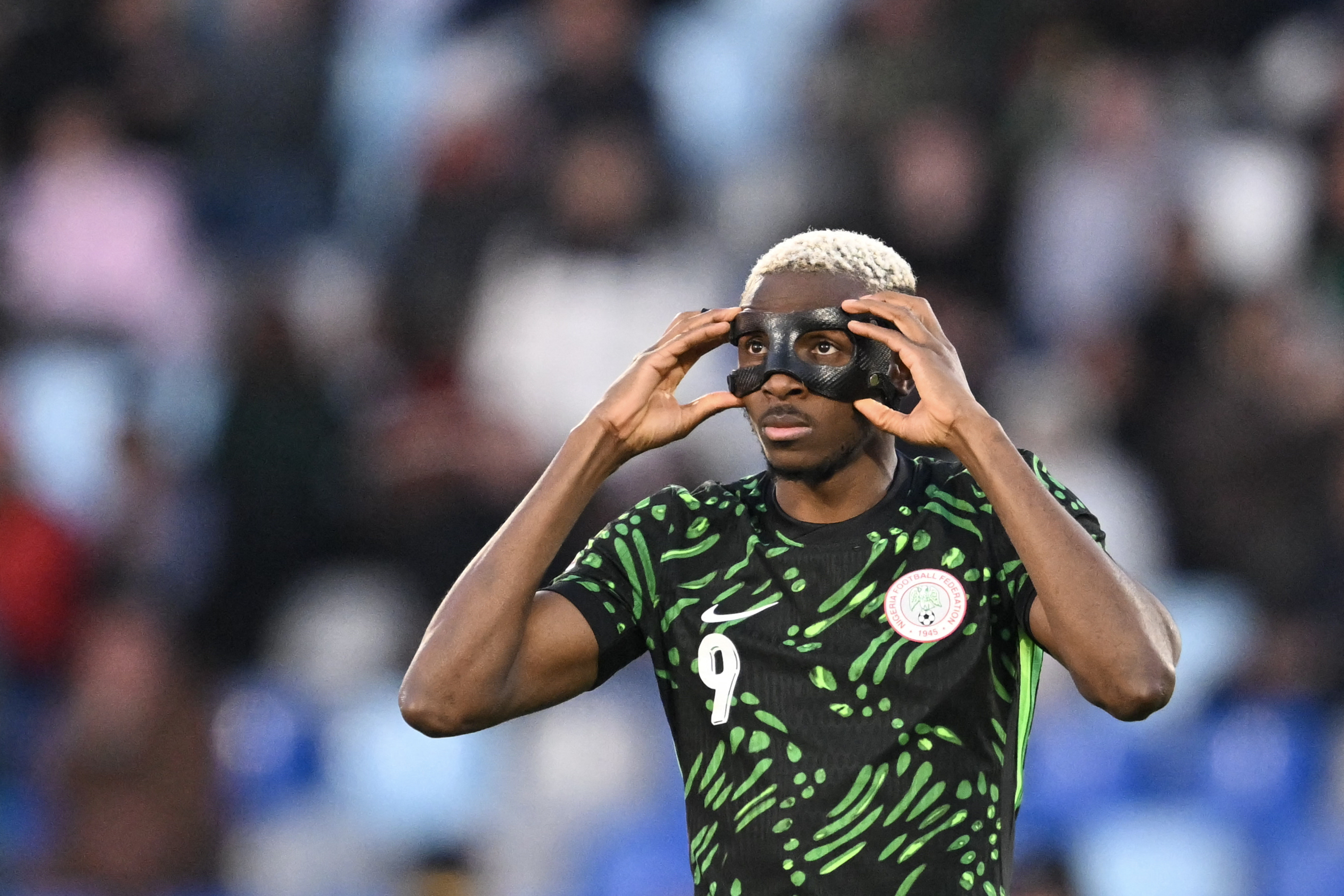 Nigeria's forward #09 Victor Osimhen adjusts his mask during the Africa Cup of Nations (CAN) quarter-final football match between Algeria and Nigeria at the Grand stadium in Marrakesh on January 10, 2026.