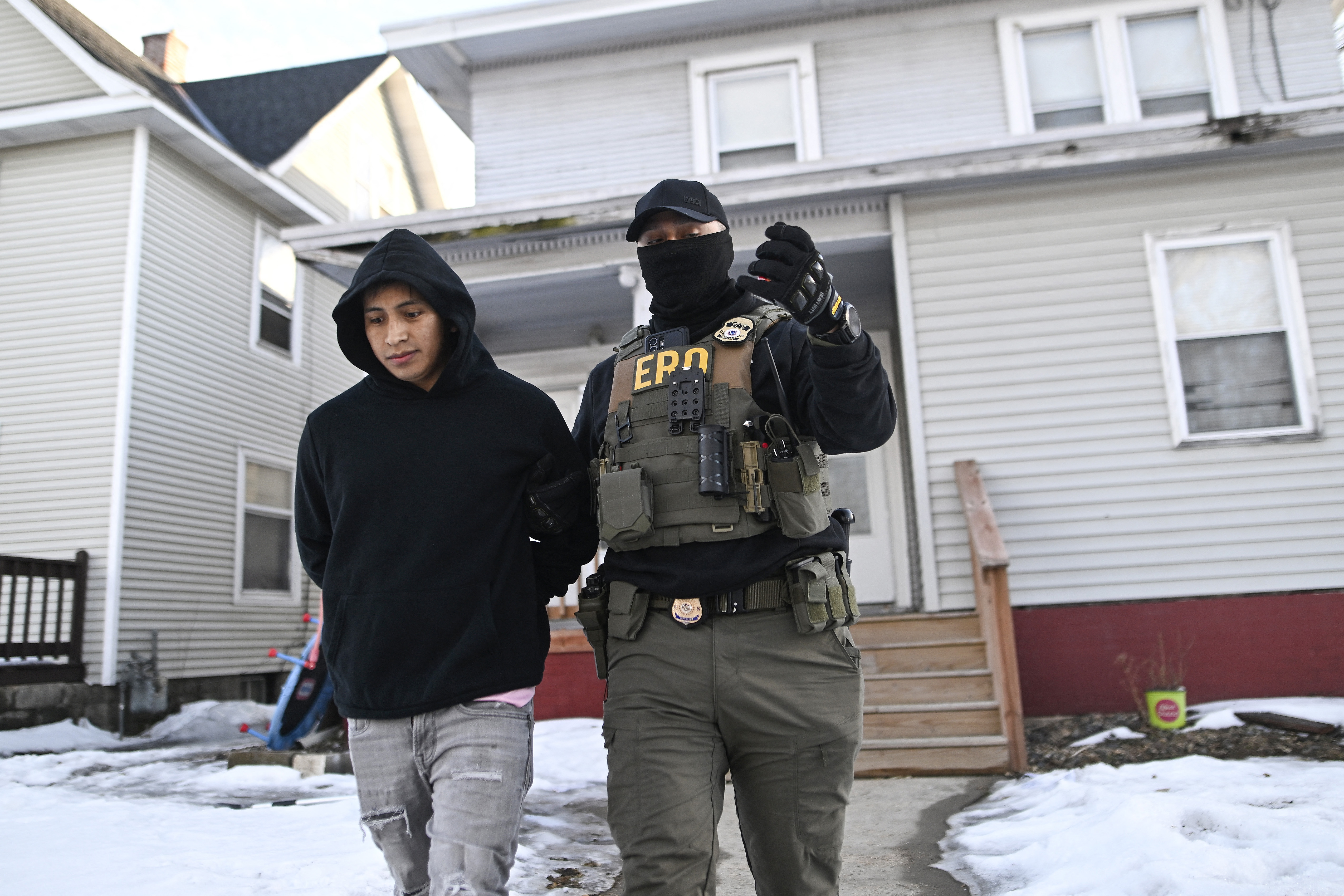 MINNEAPOLIS, MINNESOTA - JANUARY 13: An ICE Enforcement and Removal Operations agent detains a person from a house on January 13, 2026 in Minneapolis, Minnesota. The Trump administration has deployed over 2,400 Department of Homeland Security agents to the state of Minnesota in a push to apprehend undocumented immigrants. Stephen Maturen/Getty Images/AFP (Photo by Stephen Maturen / GETTY IMAGES NORTH AMERICA / Getty Images via AFP)