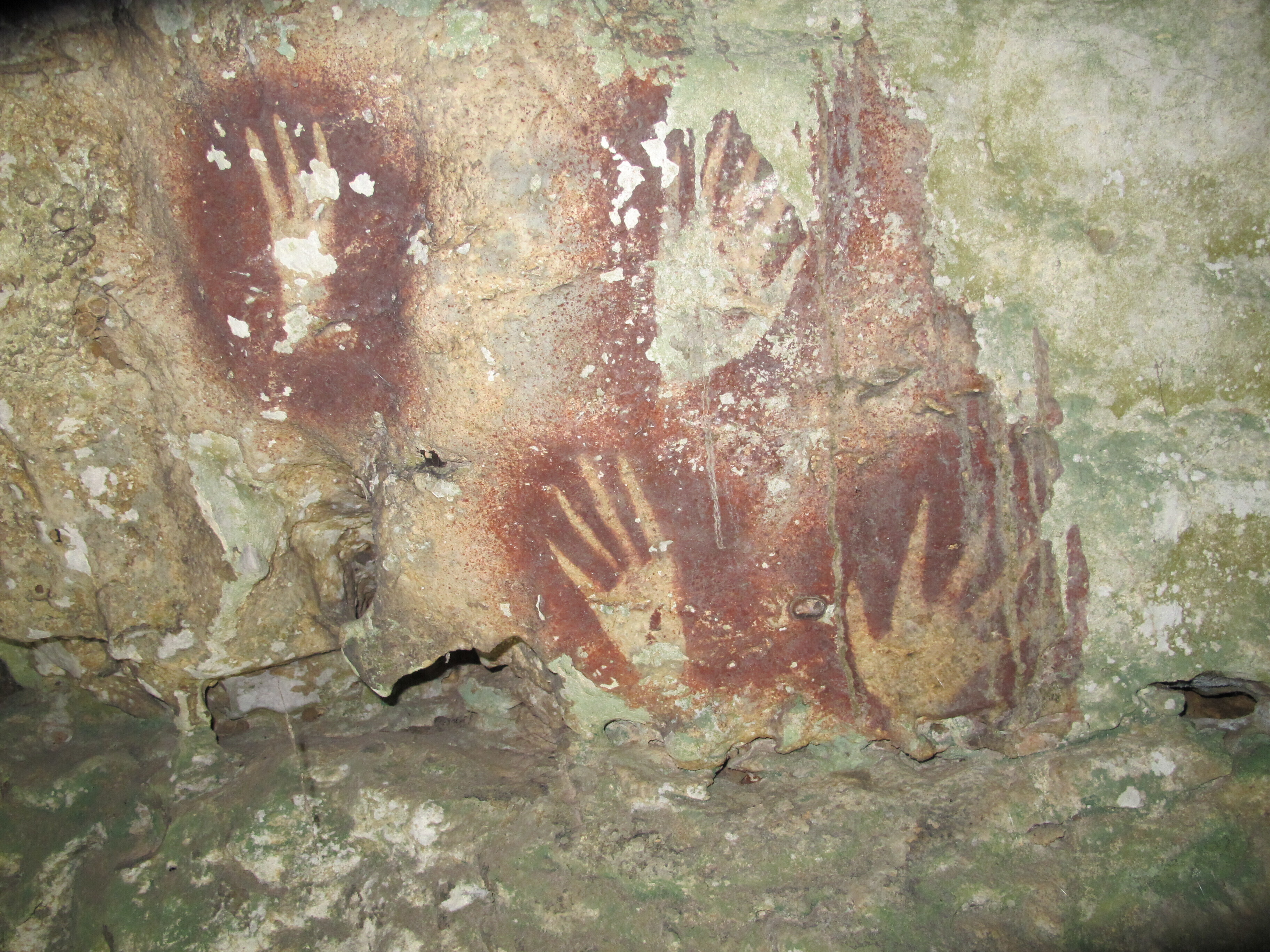 This undated image provided by Maxime Aubert shows handprints with sharpened fingertips in the Maros region of Sulawesi, Indonesia. (Ahdi Agus Oktaviana/Maxime Aubert via AP)