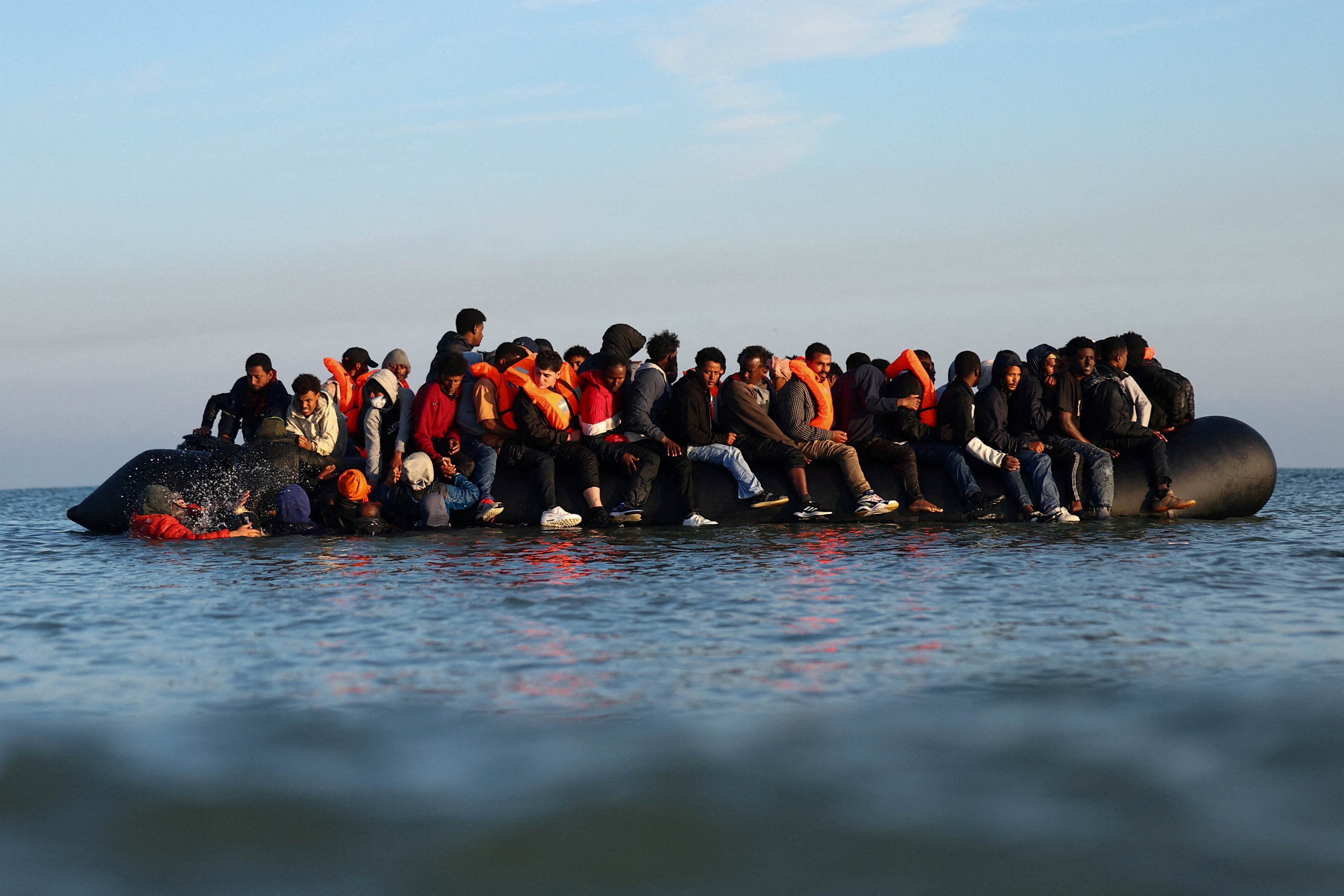 FILE PHOTO: A group of migrants on an inflatable dinghy leave the beach of Petit-Fort-Philippe in northern France in an attempt to cross the English Channel to reach Britain, in Gravelines, near Calais, France, September 27, 2025. REUTERS/Abdul Saboor/File Photo