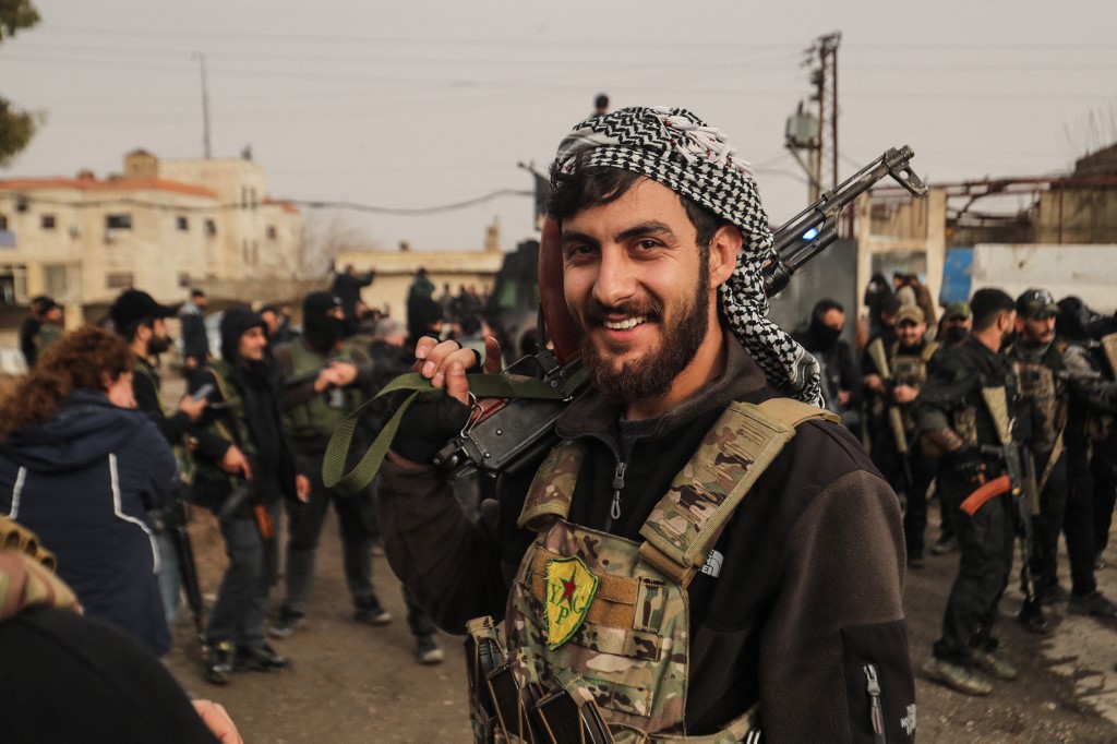 A member of the Kurdish forces reacts.