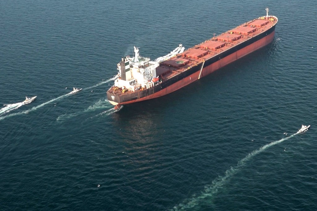 Boats manoeuvre around a tanker vessel during an IRGC military exercise in the Strait of Hormuz