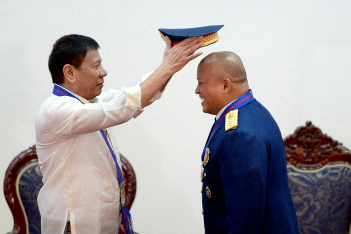 Philippine President Rodrigo Duterte gestures puts a hat on Philippine National Police (PNP) chief Ronald “Bato” Dela Rosa during Dela Rosa's Assumption of Command Ceremony at the Camp Crame in Manila on July 1, 2016. Authoritarian firebrand Rodrigo Duterte was sworn in as the Philippines' president on June 30, after promising a ruthless and deeply controversial war on crime would be the main focus of his six-year term. (Photo by NOEL CELIS / AFP)