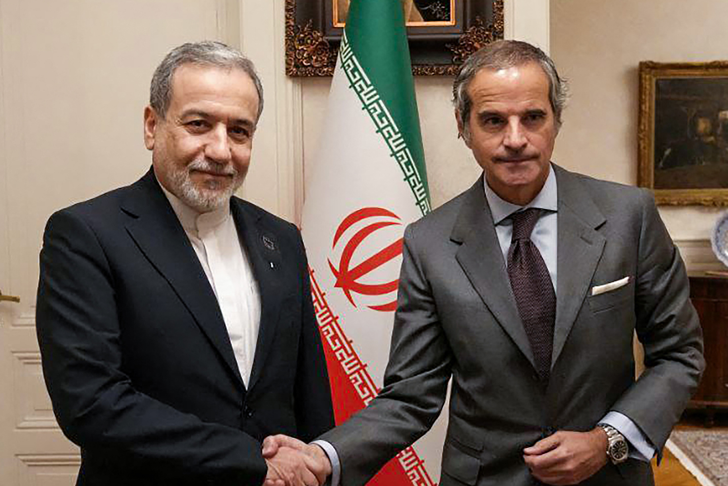 Iran's Foreign Minister Abbas Araghchi (L) shakes hands with International Atomic Energy Agency head Rafael Grossi in Geneva, Switzerland. 