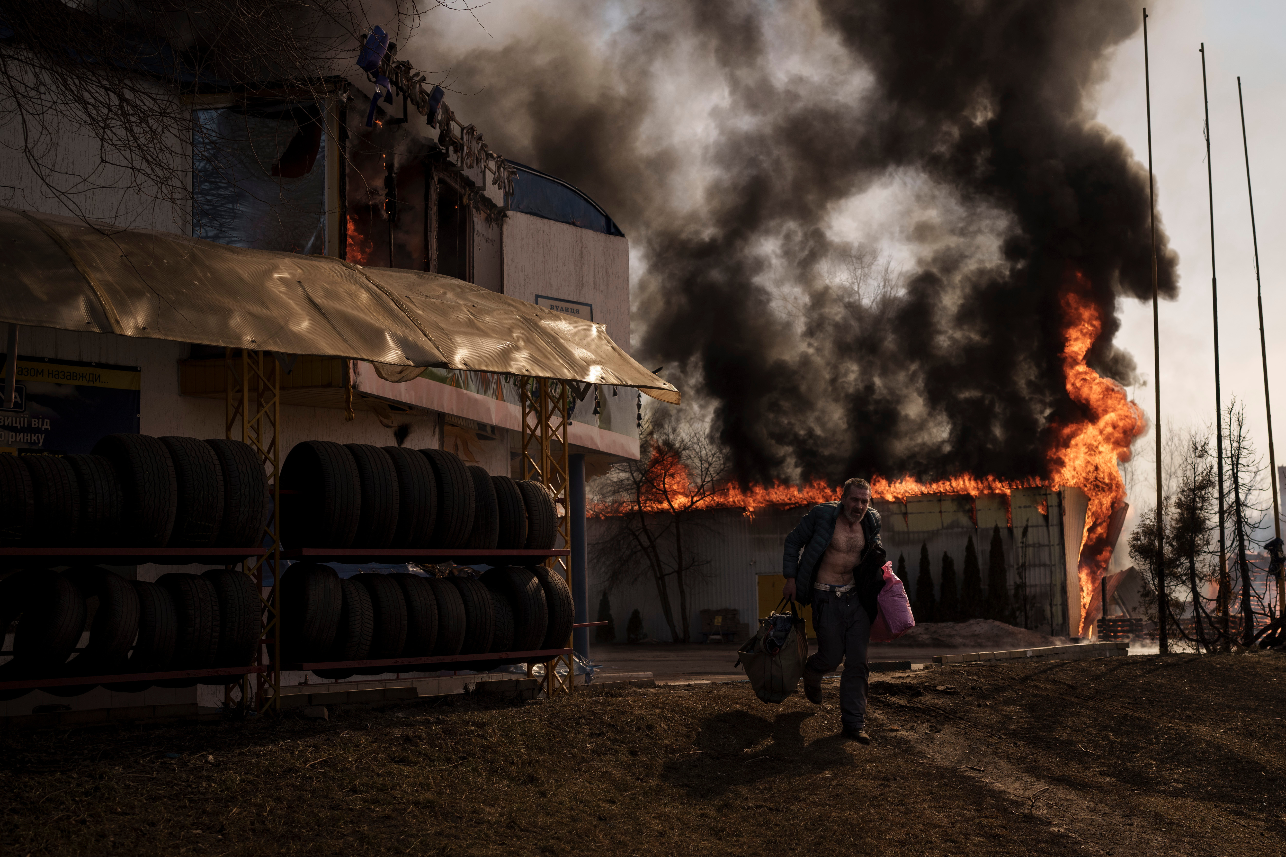 A man recovers items from a shop that caught fire in a Russian attack in Kharkiv, Ukraine