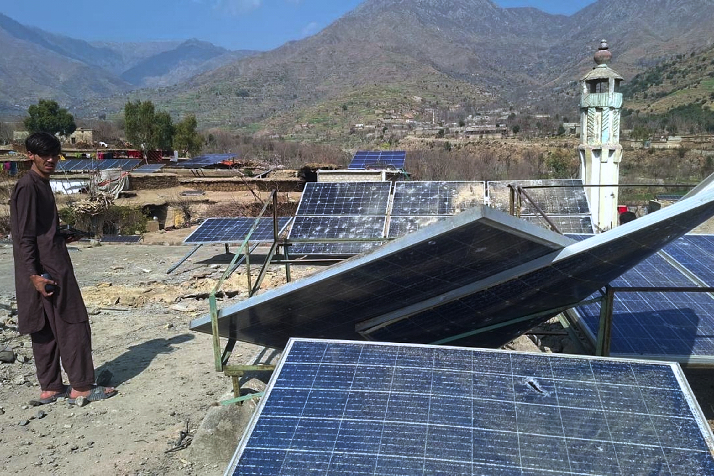 A villager looks at damaged solar plates and a portion following overnight cross border fighting between Pakistan and Afghan forces, at a village in Bajaur, a district of Pakistan's Khyber Pakhtunkhwa province bordering with Afghanistan, Friday, Feb. 27, 2026