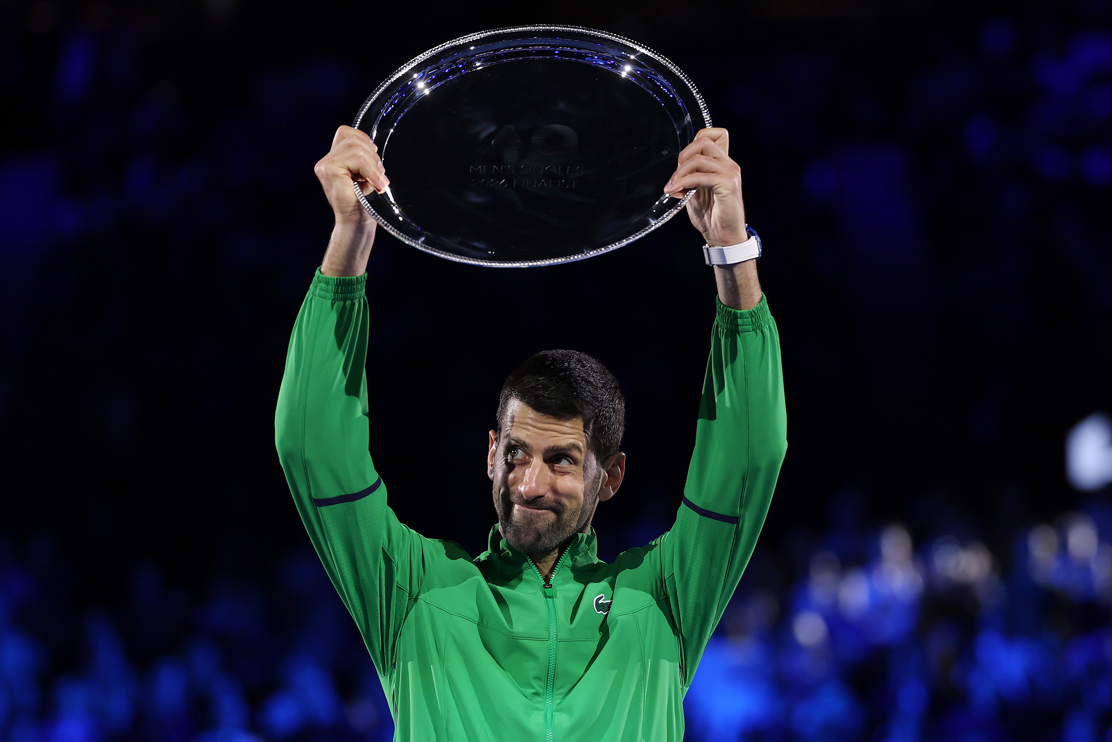 MELBOURNE, AUSTRALIA - FEBRUARY 01: Runner-up Novak Djokovic of Serbia lifts the finalist plaque to applaud the fans at the presentation ceremony after the Men's Singles Final against Carlos Alcaraz of Spain during day 15 of the 2026 Australian Open at Melbourne Park on February 01, 2026 in Melbourne, Australia. (Photo by Clive Brunskill/Getty Images)