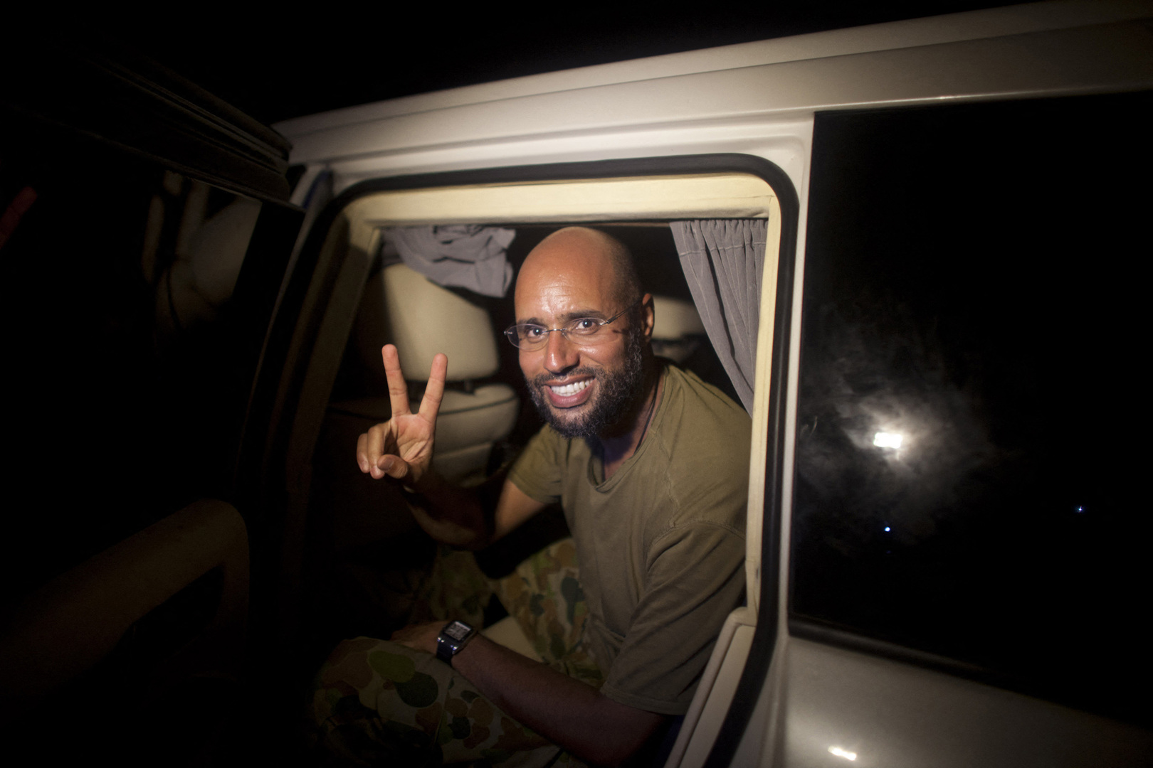 Saif al-Islam Gaddafi, son of Libyan leader Moamer Kadhafi appears in front of supporters and journalists in the Libyan capital Tripoli in the early hours of August 23, 2011. Seif al-Islam, then-wanted by the International Criminal Court for crimes against humanity and who ICC prosecutor Luis Moreno-Ocampo earlier said had been arrested by the rebels, claimed the insurgents had suffered "heavy casualties" when they stormed Gaddafi&rsquo;s Bab al-Azizya compound in Tripoli. [Dario Lopez-Mills/AFP]