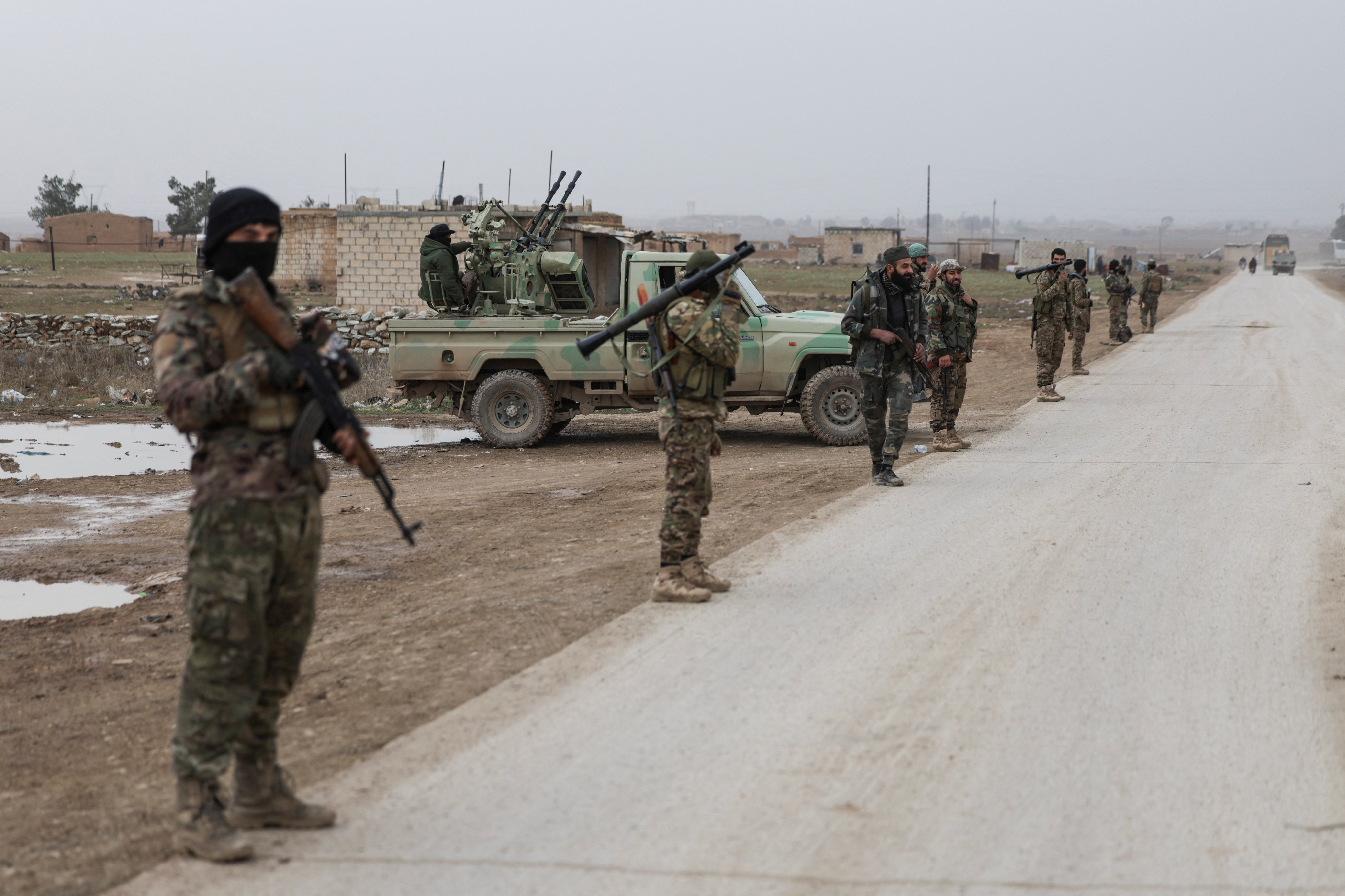 Army members stand next to a road at a Syrian army checkpoint on the outskirts of the city of Al-Hasakah, Syria, February 2, 2026. REUTERS/Khalil Ashawi