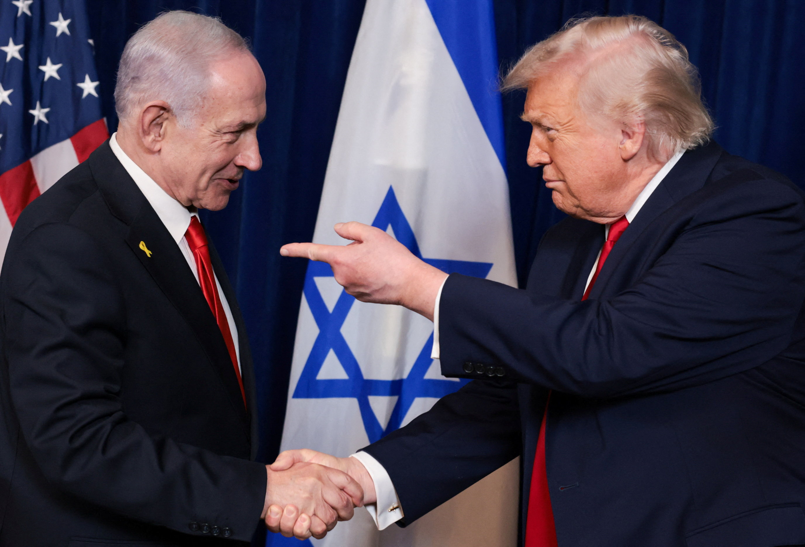 US President Donald Trump and Israeli Prime Minister Benjamin Netanyahu shake hands and speak.