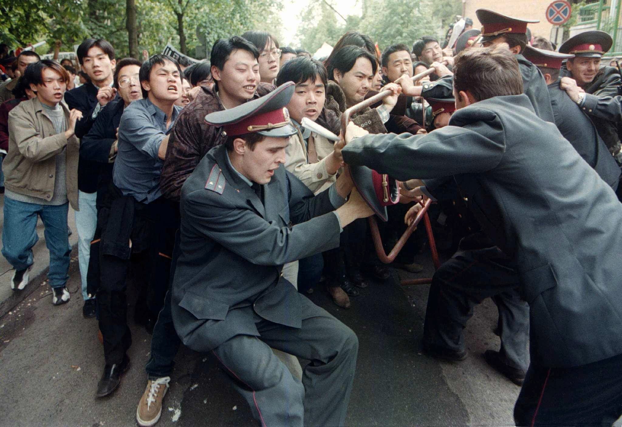 Chinese students break through a line of police officers at the US embassy in Kiev, Ukraine, 11 May 1999, during their protest against the bombing of the Chinese embassy in Belgrade