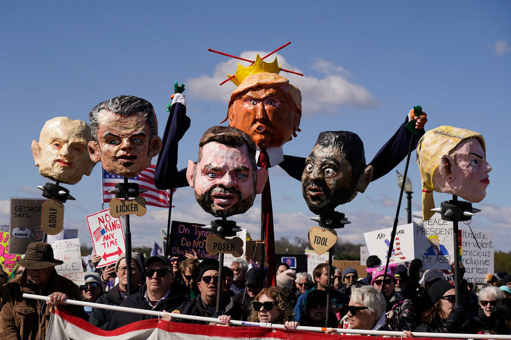 Demonstrators with caricatures of various members of the Trump administration