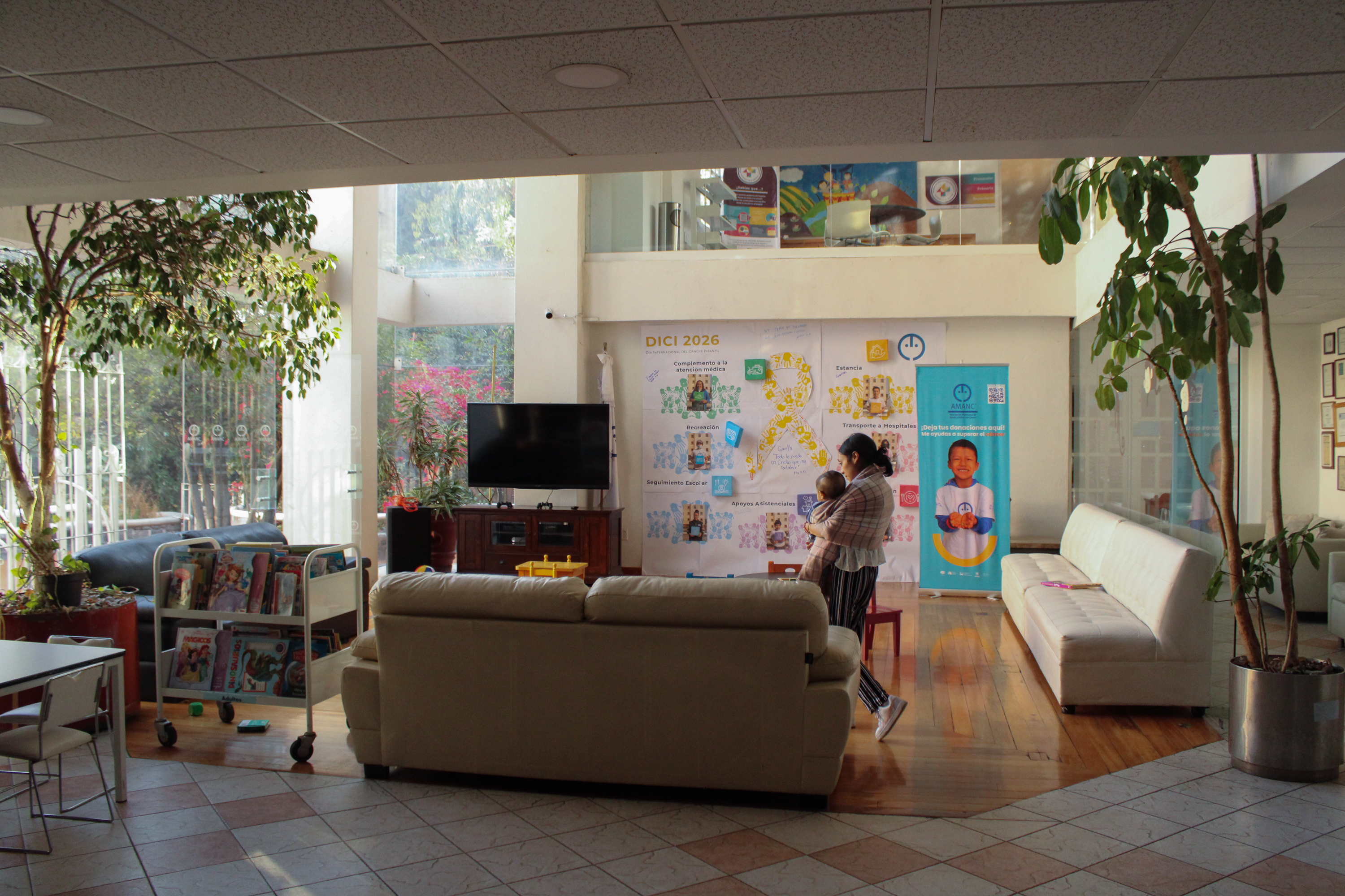 Luisa walks through the centre carrying Juan de Jesús, navigating long days of caregiving far from her home community_-1773831292