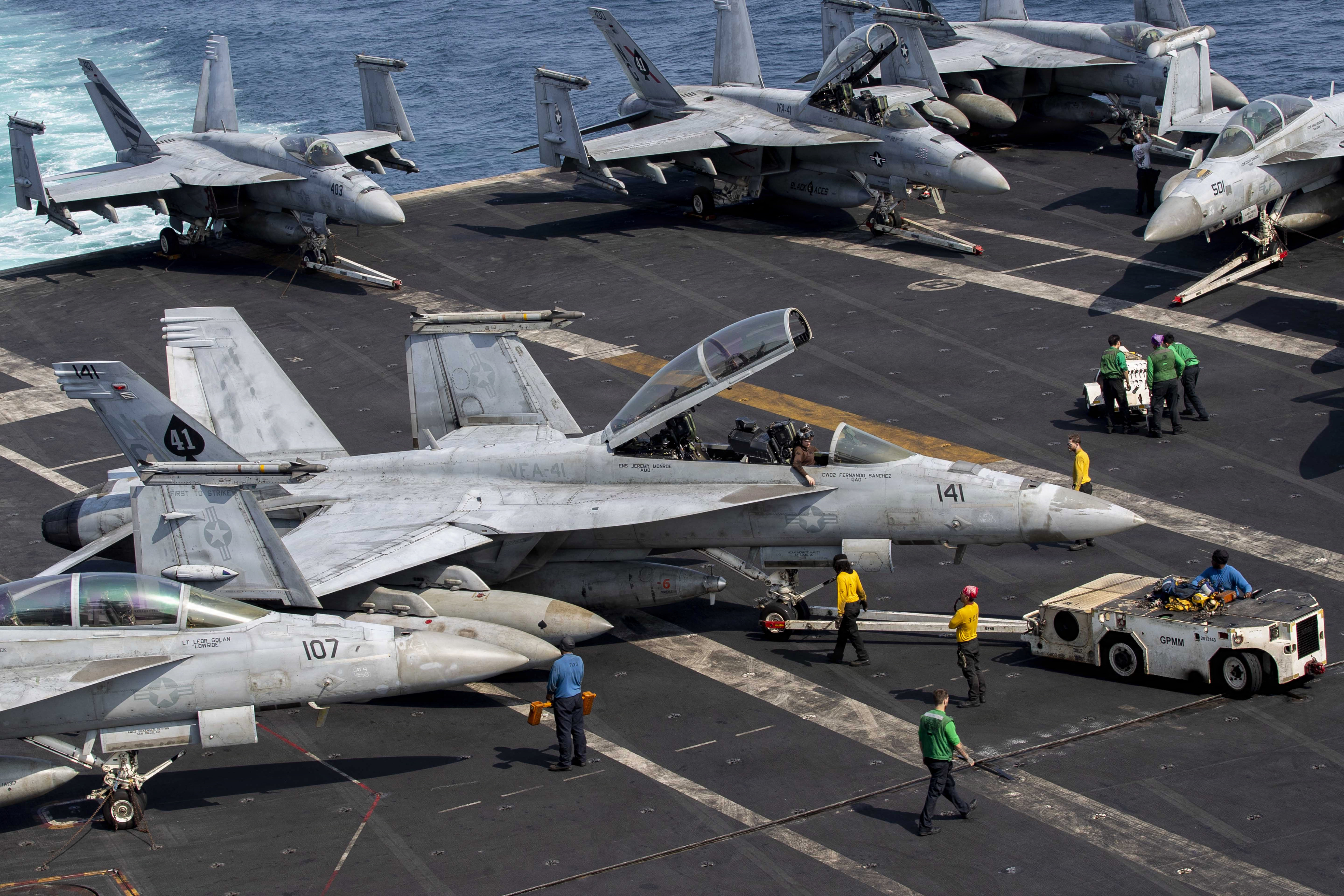 This US Navy handout photo released on March 18, 2026 by US Central Command public affairs, shows US sailors taxiing an F/A-18F Super Hornet, attached to Strike Fighter Squadron (VFA) 41, on the flight deck aboard Nimitz-class aircraft carrier USS Abraham Lincoln (CVN 72), in support of Operation Epic Fury, on March 17, 2026.