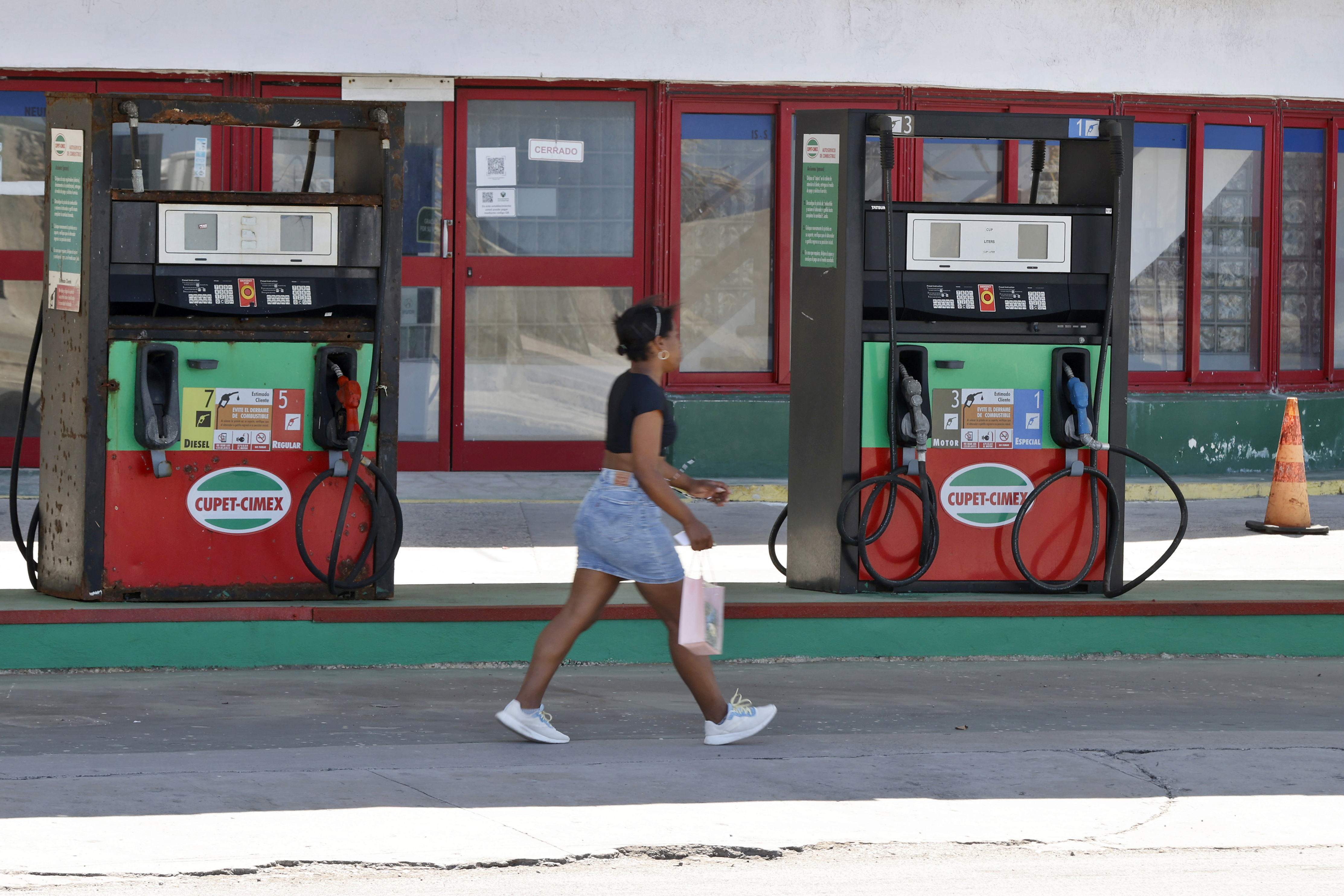 epaselect epa12859110 A person walks past a gas station in Havana, Cuba, 27 March 2026 (issued 29 March 2026). Cuba has been without 'a drop of fuel' for three months due to the US oil embargo, according to its own government, and the economy is suffering. EPA/Ernesto Mastrascusa