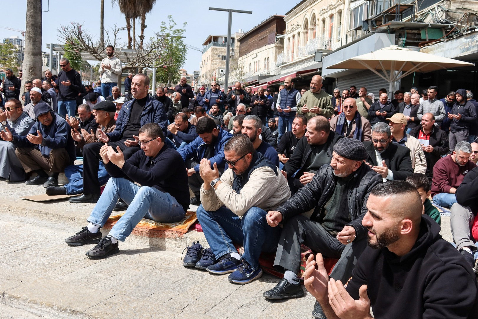 Palestinian Muslim worshippers attend a prayer by a road, as they are not permitted to attend the last Friday prayers at Al-Aqsa compound, also known to Jews as the Temple Mount, for the Muslim holy fasting month of Ramadan, following restrictions on gathering in large groups, amid the US-Israeli conflict with Iran, by Damascus Gate in Occupied East Jerusalem on March 13, 2026. [Sinan Abu Mayzer/Reuters]