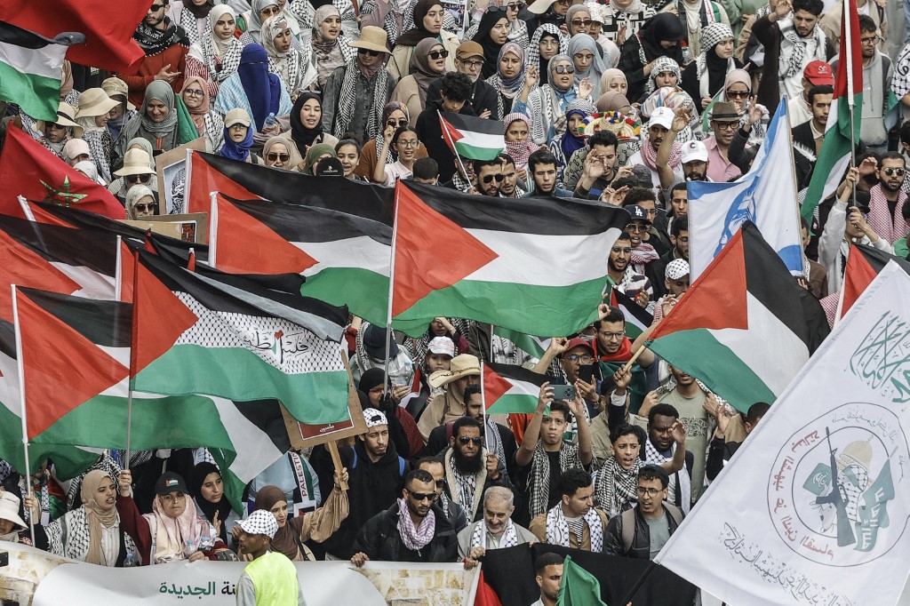 Moroccan protesters display signs supporting Palestinians during a mobilisation against diplomatic ties with Israel [Abdel Majid BZIOUAT / AFP]