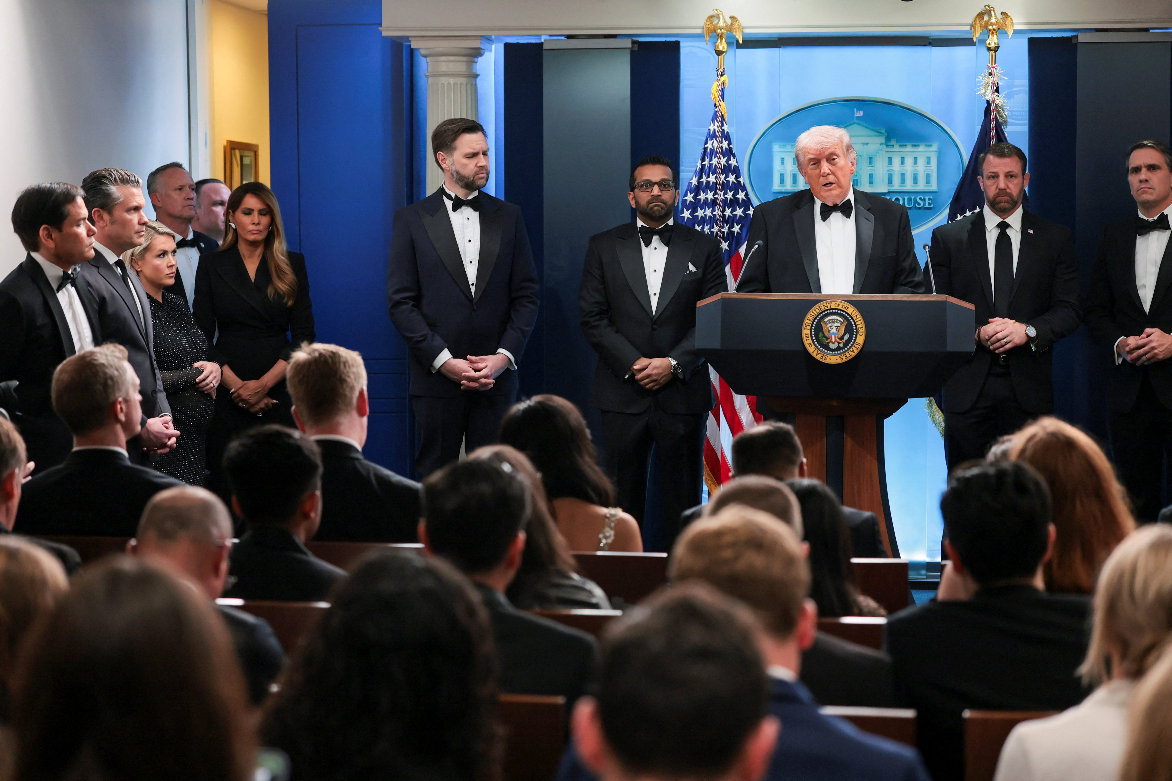 U.S. President Donald Trump speaks as Federal Bureau of Investigation (FBI) Director Kash Patel, acting Attorney General Todd Blanche, Vice President JD Vance, Homeland Security Secretary Markwayne Mullin, first lady Melania Trump, White House Press Secretary Karoline Leavitt, U.S. Secretary of Defense Pete Hegseth and U.S. Secretary of State Marco Rubio listen, at a press briefing at the White House, following a shooting incident during the annual White House Correspondents’ Association dinner, in Washington, D.C., U.S., April 25, 2026