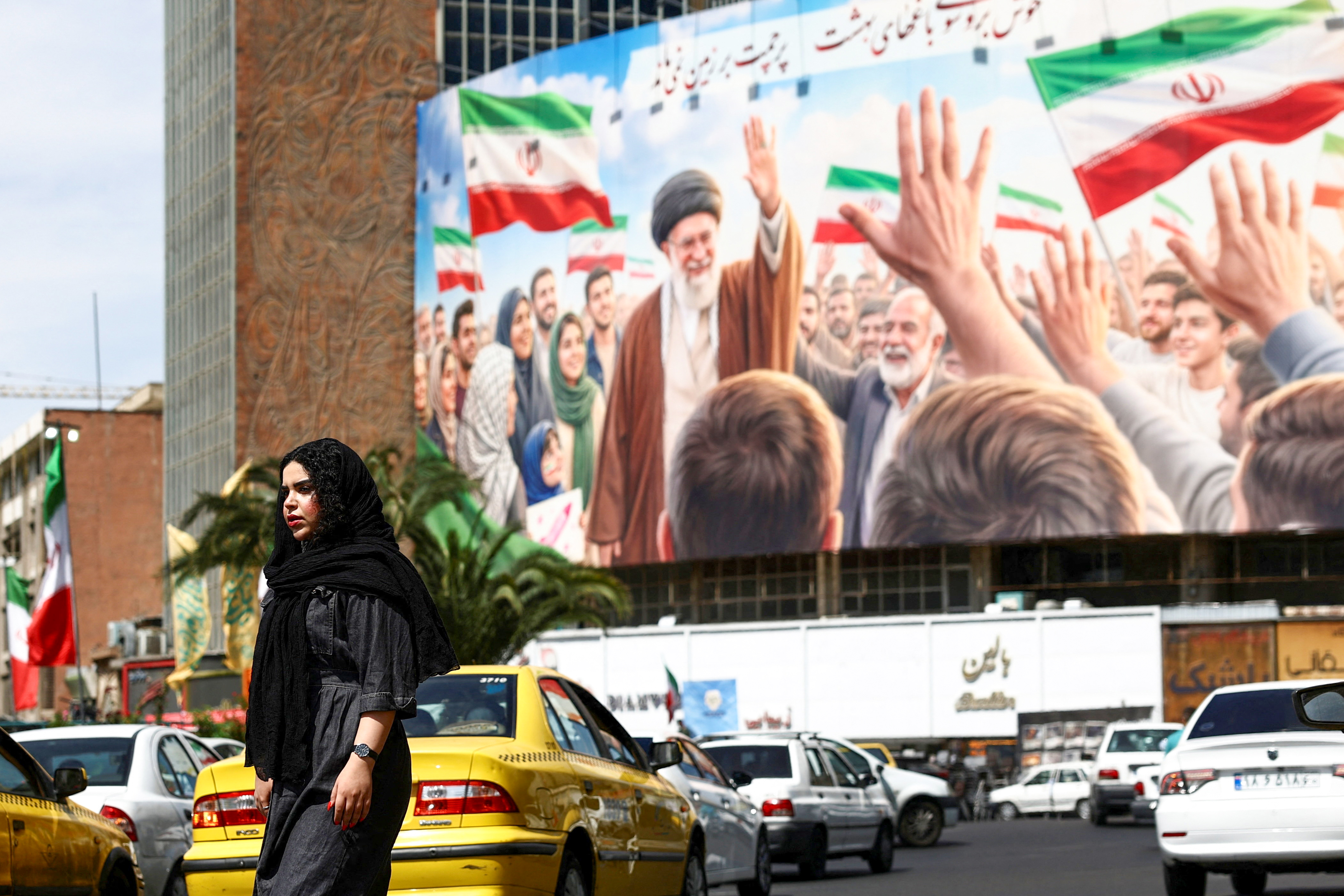 A woman walks past a billboard featuring an image of the late Supreme Leader of Iran, Ayatollah Ali Khamenei, on a building, amid a ceasefire between U.S. and Iran, in Tehran, Iran, April 27, 2026. Majid Asgaripour/WANA (West Asia News Agency) via REUTERS ATTENTION EDITORS - THIS PICTURE WAS PROVIDED BY A THIRD PARTY