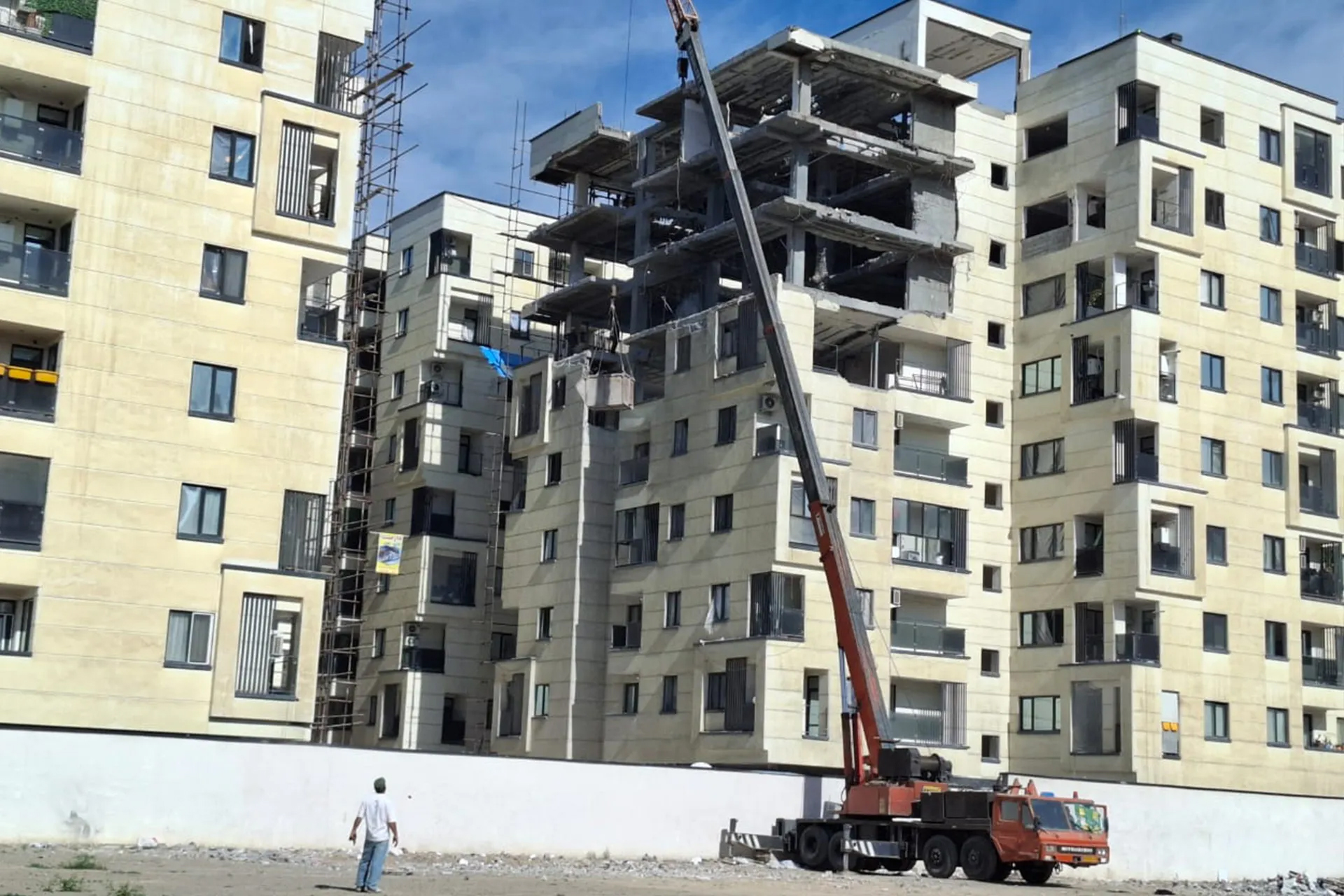 While some partially damaged buildings undergo urgent repairs, completely destroyed residential blocks remain untouched as owners await international guarantees.