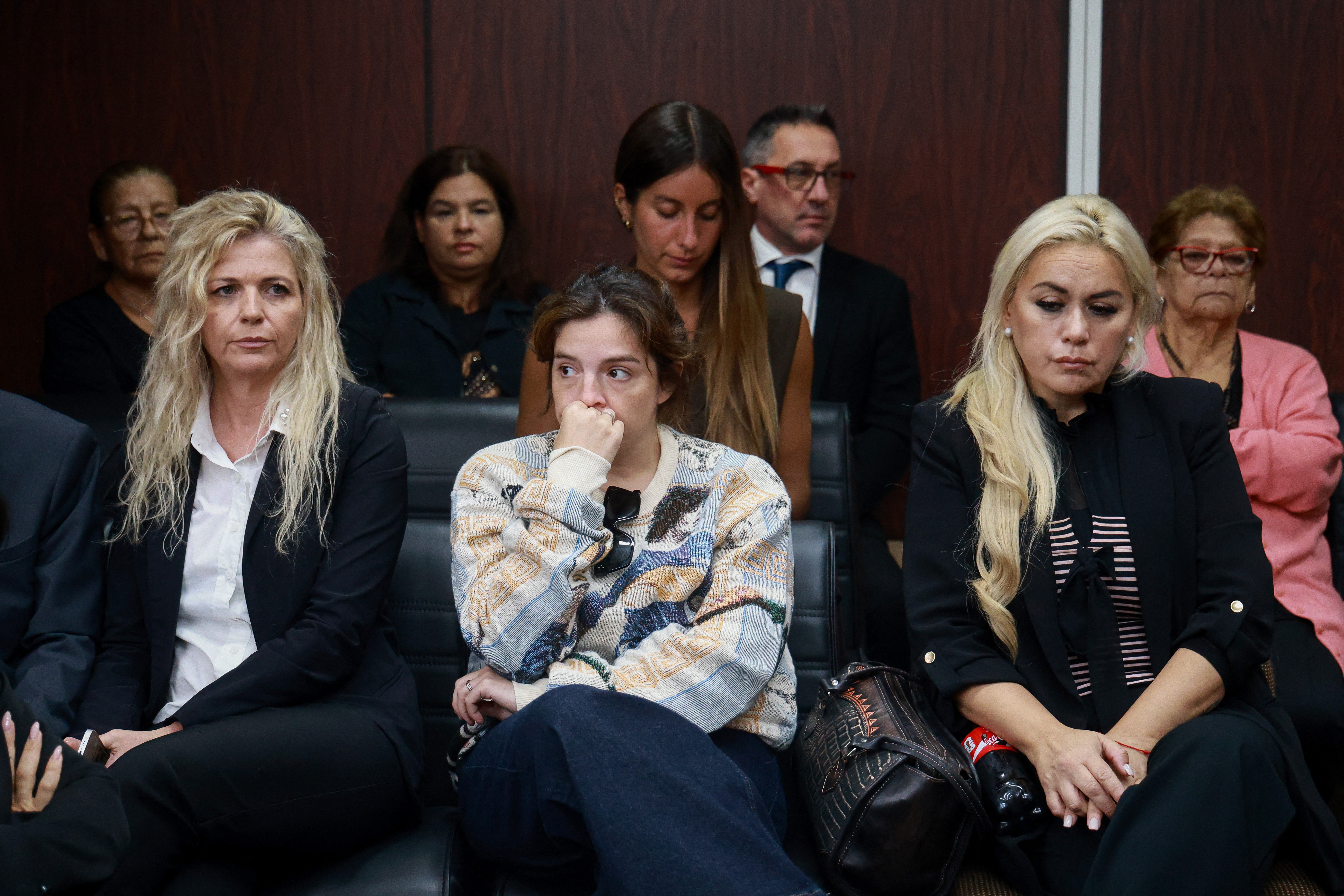 Dalma Maradona (C), daughter of Argentine football legend Diego Maradona and his former partner, Veronica Ojeda (R), are seen at a courthouse during a preliminary hearing in a trial over his death in San Isidro, outskirts of Buenos Aires on April 14, 2026. (Photo by Tomas CUESTA / AFP)