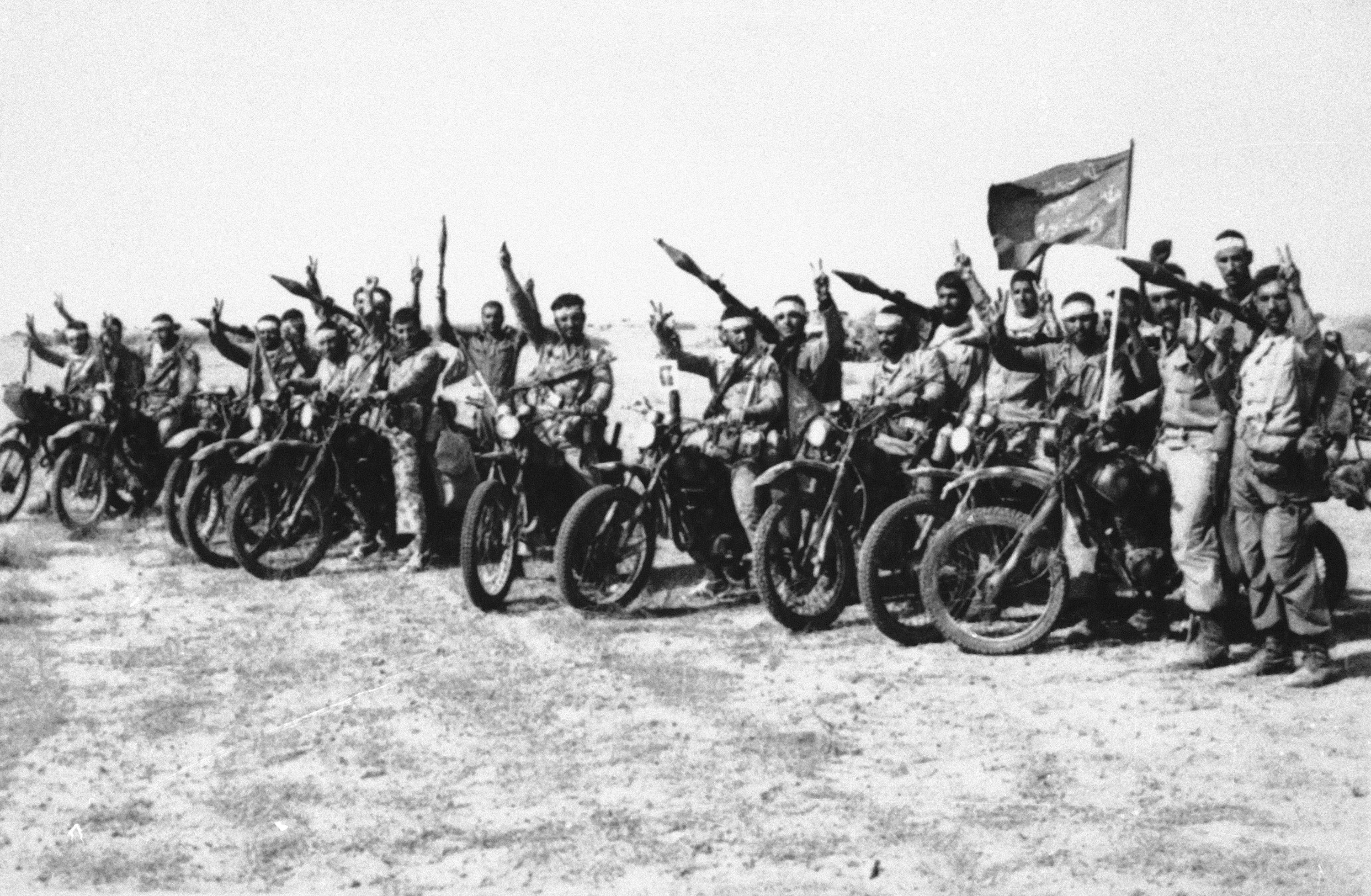 A group of Iranian Revolutionary Guards and volunteer tank hunters give victory signs somewhere on the southern front of Iran's 27-month-old war with Iraq, Dec. 1982. Mounted on motorcycles, and armed with Soviet-made rocket-propelled grenades, the hunters form a fast, highly-mobile force for use against Iraqi armor. (AP Photo)