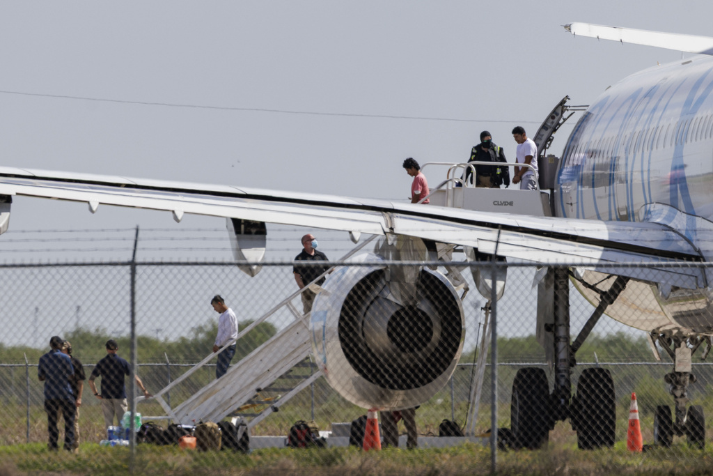 Shackled migrants deplane an aircraft used for deportation flights at the Valley International Airport, Sunday, Aug. 31, 2025, in Harlingen, Texas. (AP Photo/Michael Gonzalez)
