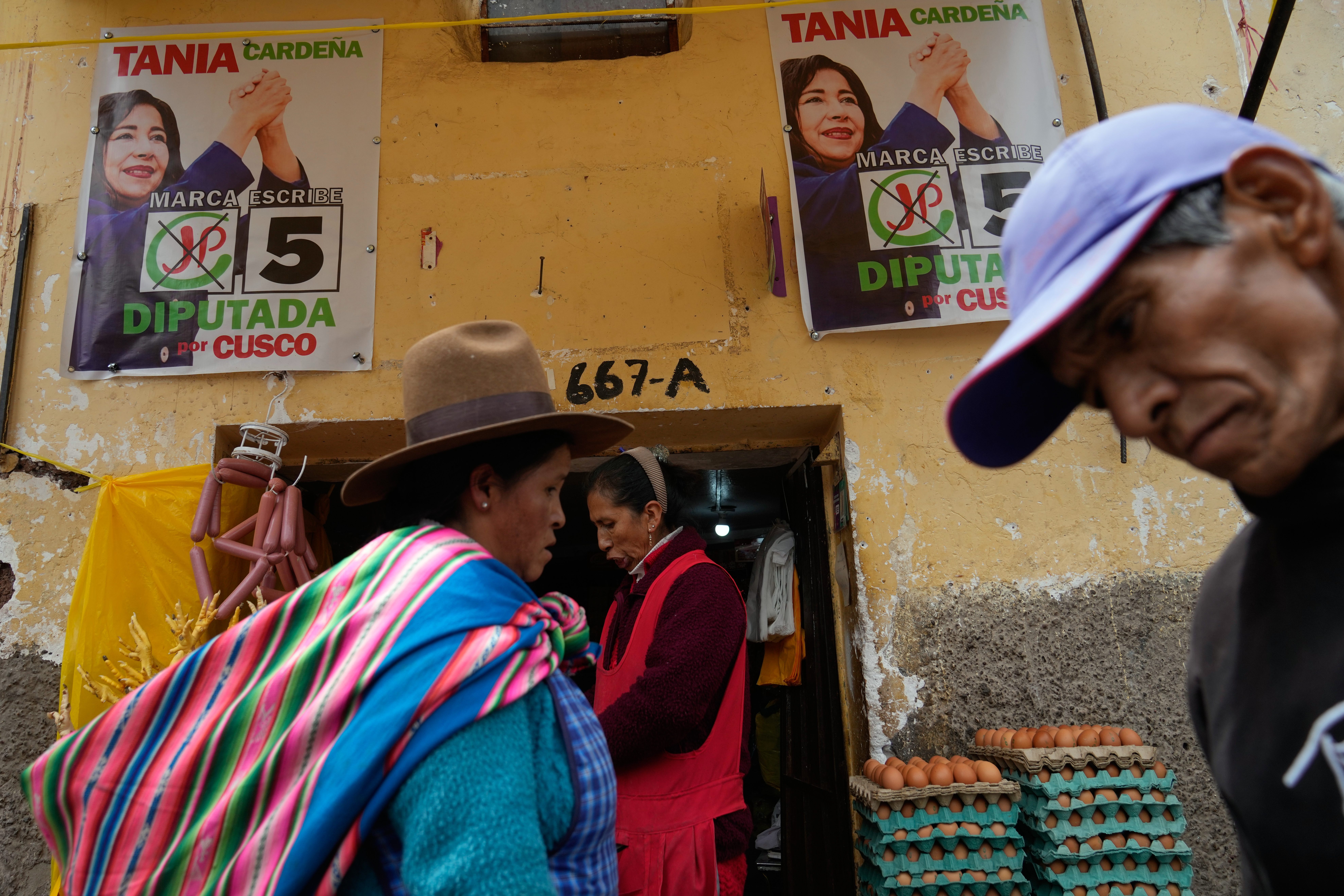 Pedestrians pass campaign signs before the weekend's presidential election in Cuzco, Peru, Wednesday, April 8, 2026. (AP Photo/Martin Mejia)