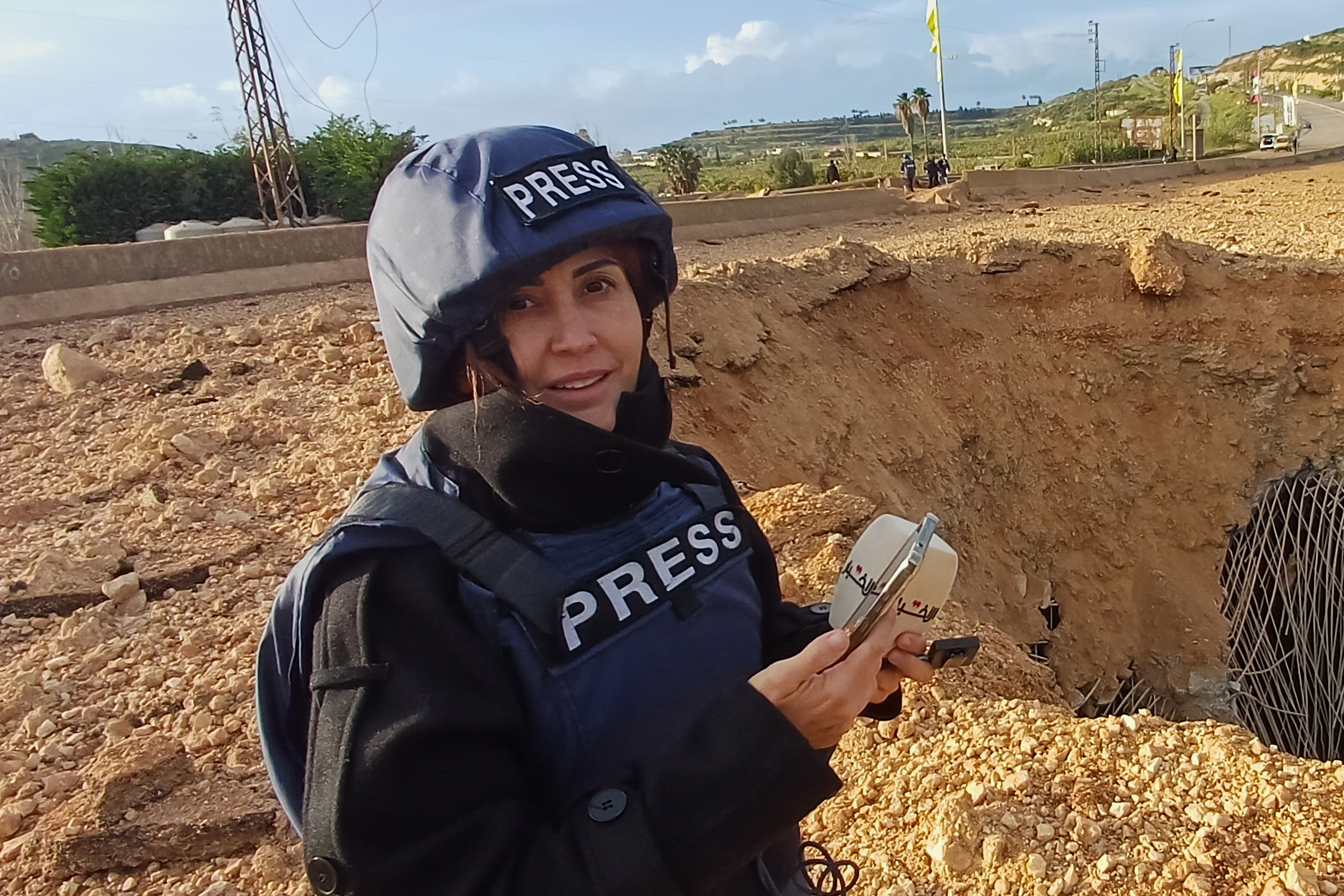 Lebanese journalist Amal Khalil, who works for the daily Al-Akhbar newspaper, reports near a destroyed bridge in Qasmiyeh, Lebanon, Sunday, March 22, 2026. (AP Photo/Mohammed Zaatari)