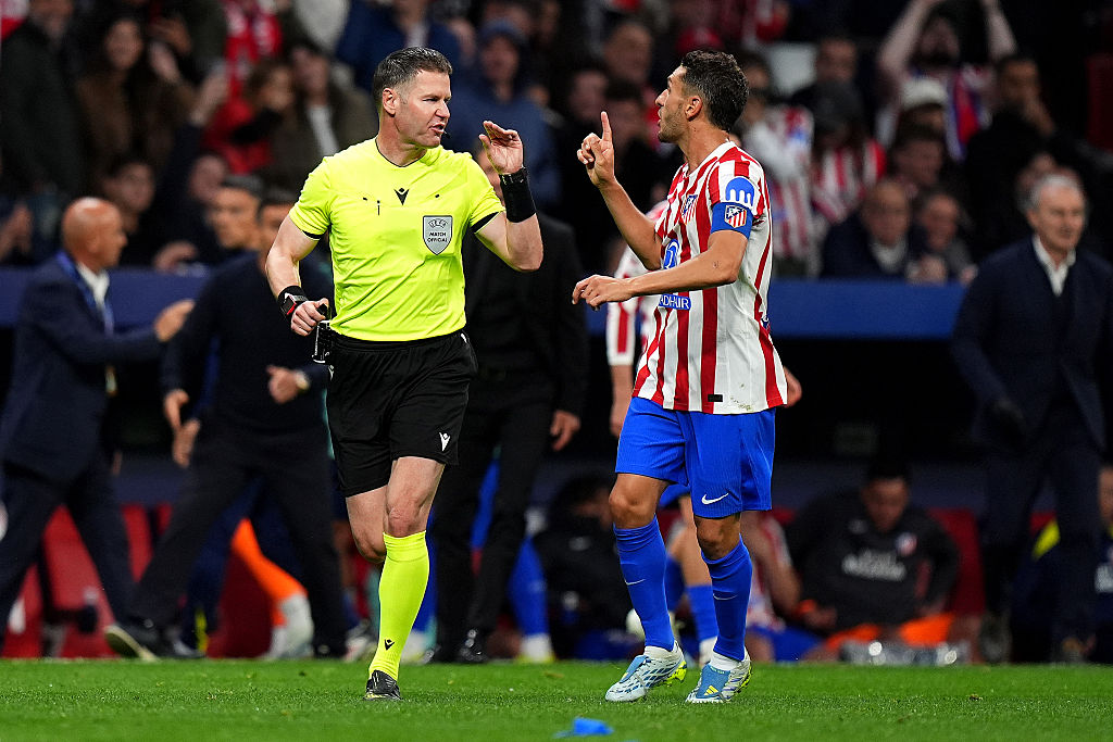 Referee Danny Makkelie reacts with Koke of Atletico de Madrid after overturning a penalty to Arsenal following a VAR review for a foul by David Hancko of Atletico de Madrid (not pictured) on Eberechi Eze of Arsenal (not pictured) during the UEFA Champions League