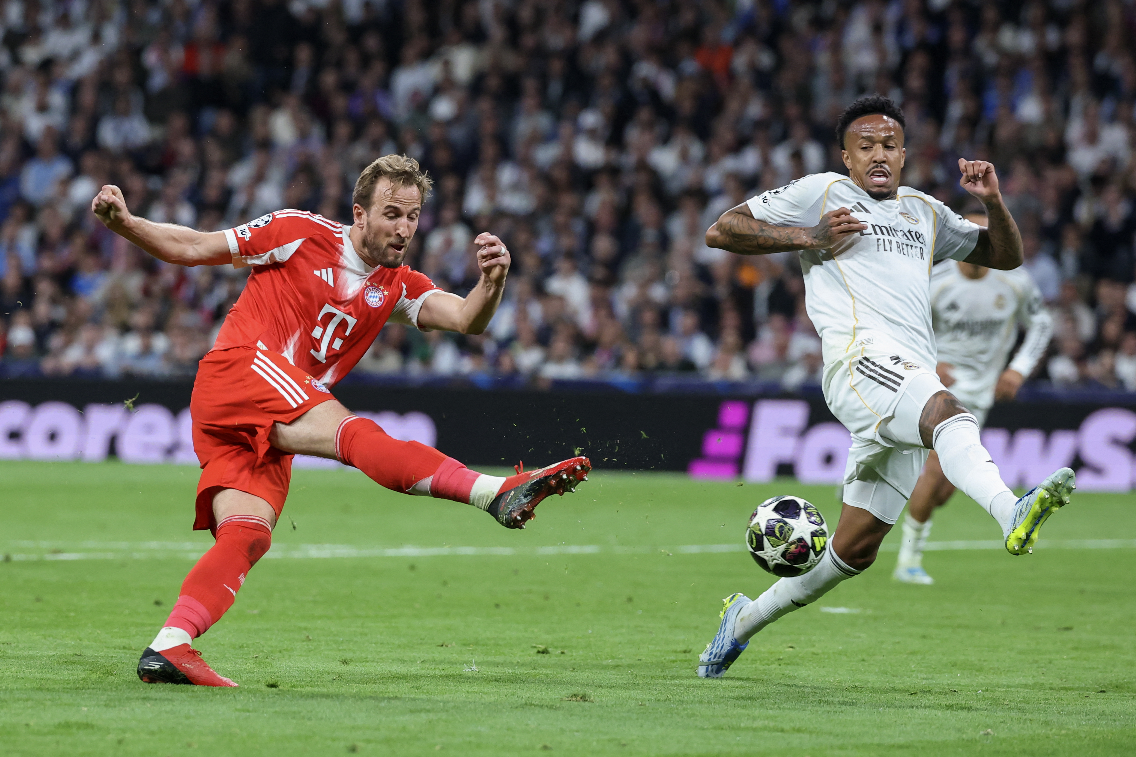 Bayern Munich's English forward #09 Harry Kane (L) shoots challenged by Real Madrid's Brazilian defender #03 Eder Militao during the UEFA Champions League quarter final first leg football match between Real Madrid CF and FC Bayern Munich at Santiago Bernabeu Stadium in Madrid on April 7, 2026.