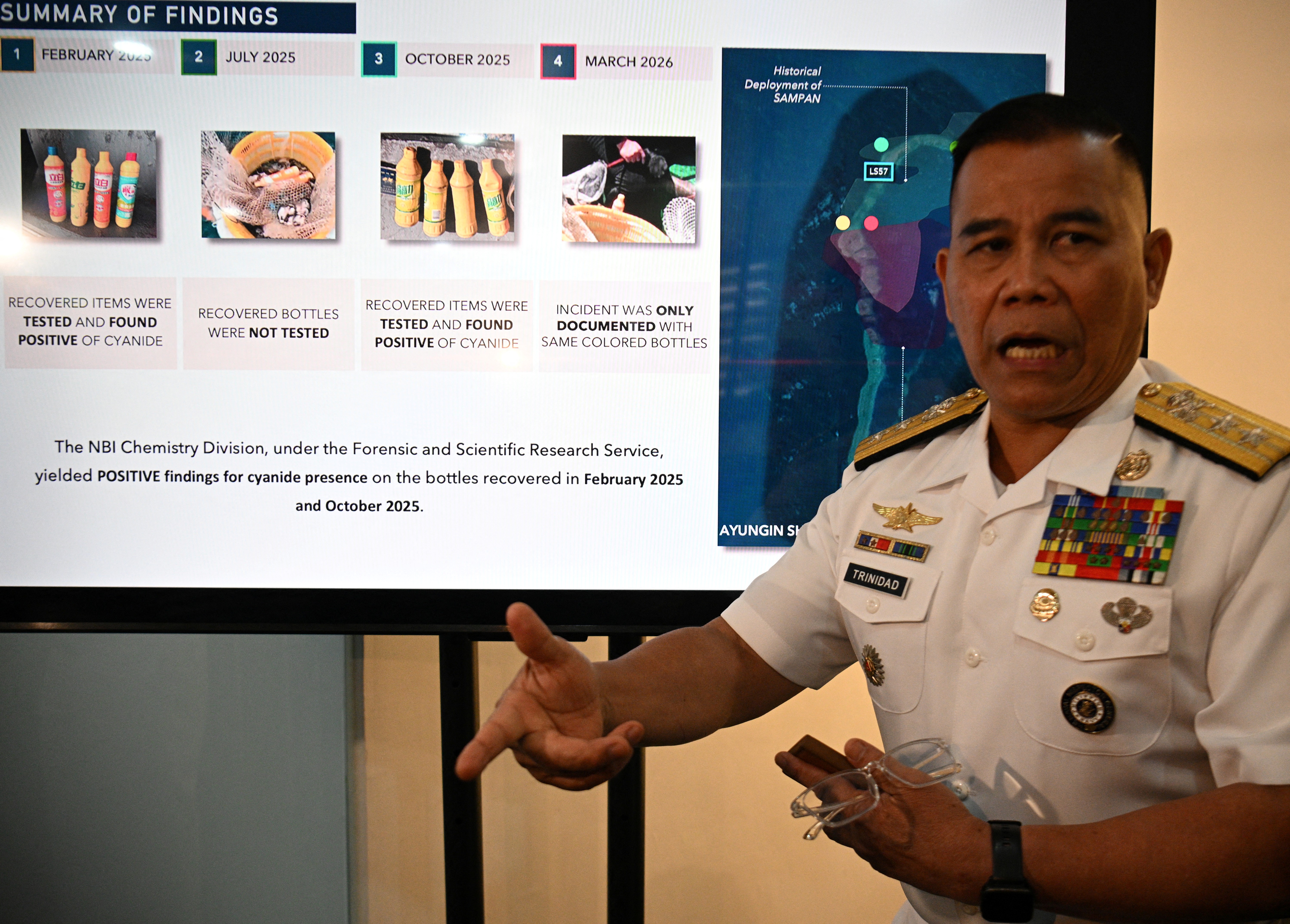 Philippine Navy spokesman Rear Admiral Roy Vincent Trinidad speaks next to a slide presentation of seized yellow bottles suspected to contain cyanide in waters of Second Thomas Shoal in the disputed South China Sea, during a press conference in Manila on April 13, 2026.