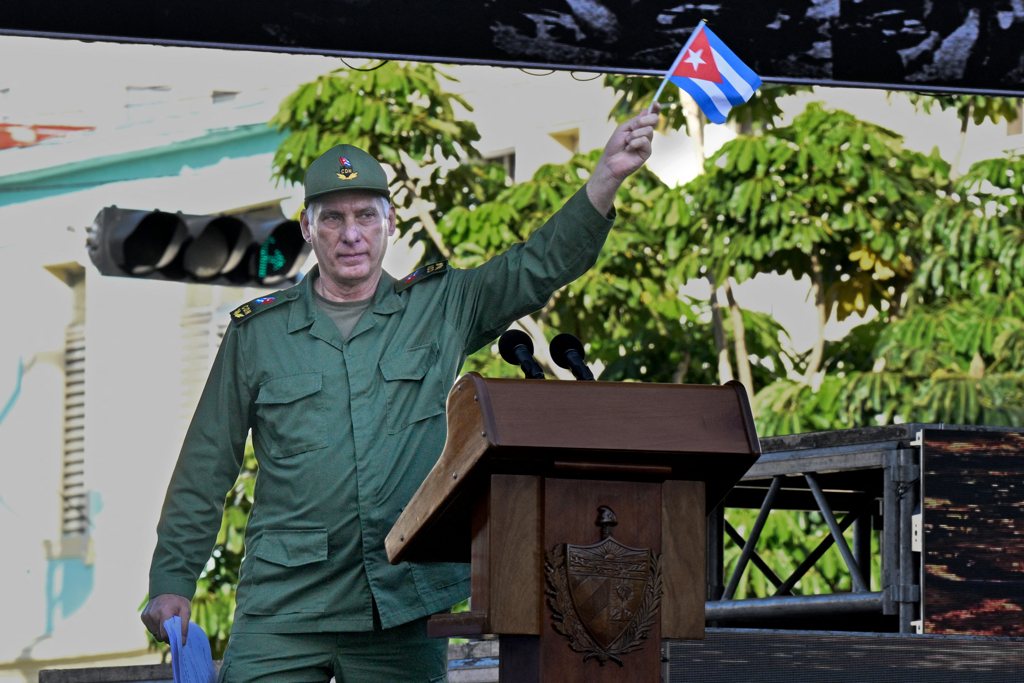 Cuba's President Miguel Diaz-Canel waves a national flag during celebrations marking the victory on the 65th anniversary of the Bay of Pigs invasion and the declaration of the socialist character of the Cuban Revolution in Havana on April 16, 2026.