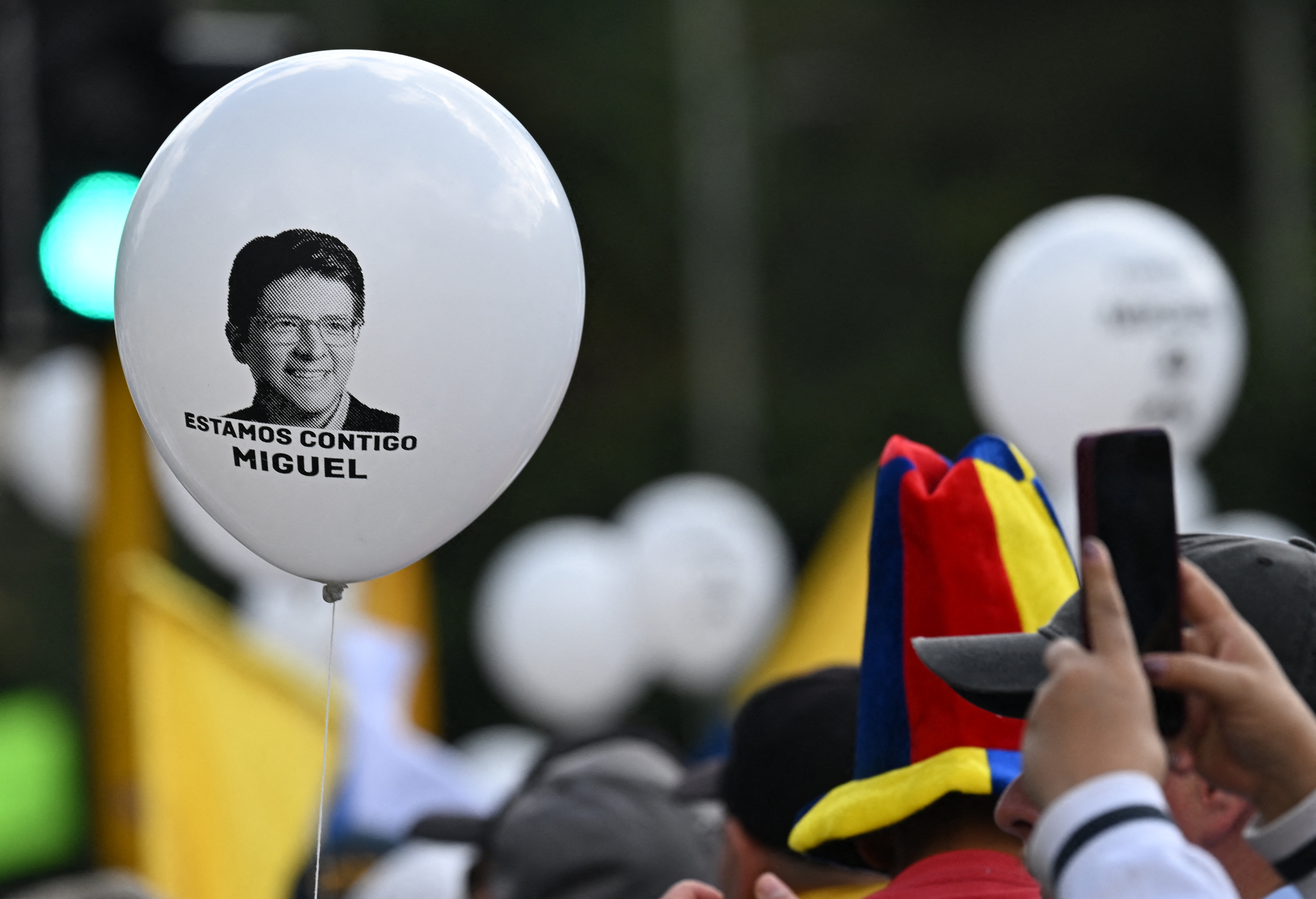 (FILES) People hold white balloons during the so-called "Silent March" to show support for the health of Senator Miguel Uribe Turbay and to call for peace for the country in Bogota on June 15, 2025.