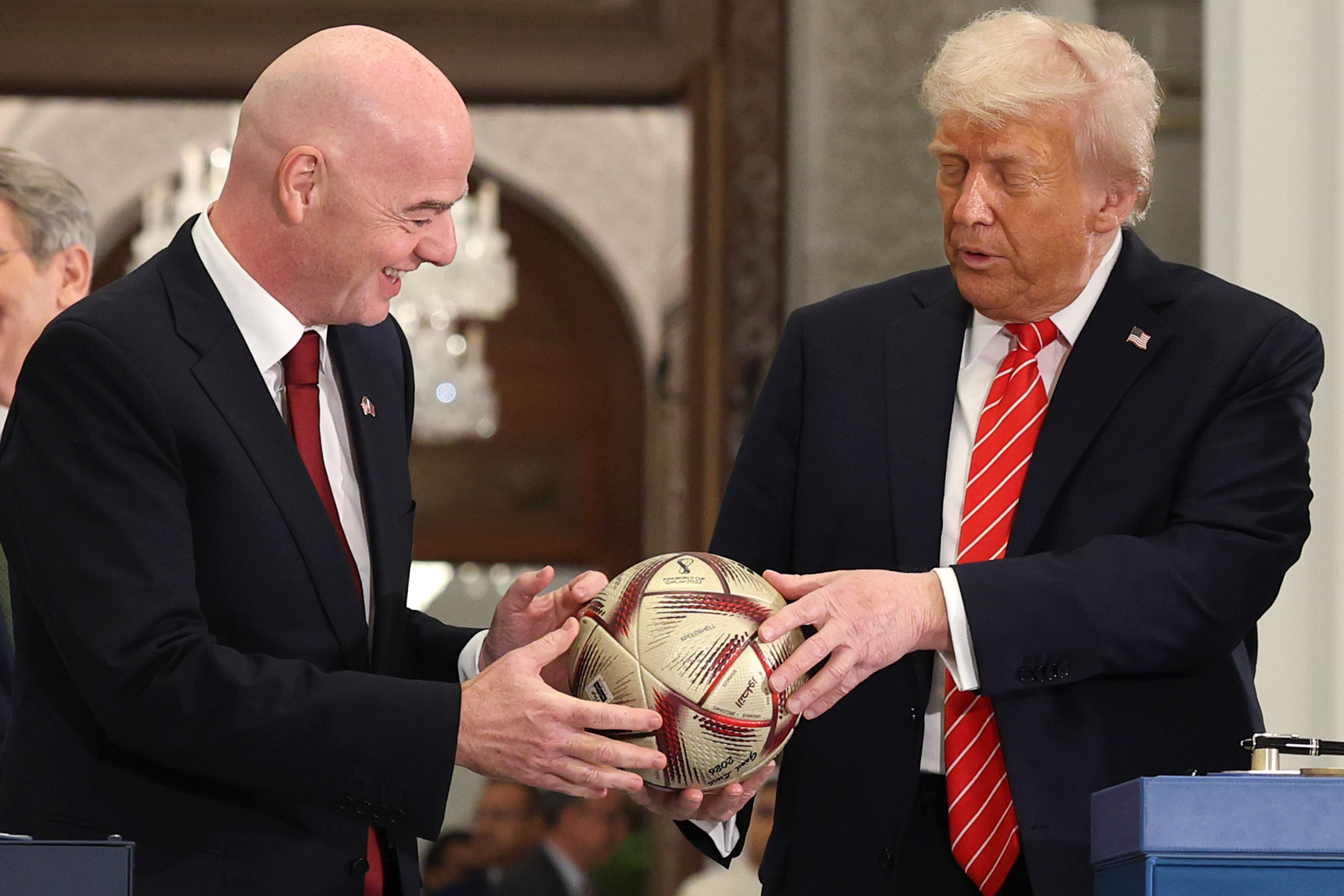 DOHA, QATAR - MAY 14: (L-R) FIFA President Gianni Infantino and U.S. President Donald J. Trump sign a football during a World Cup 2026 ceremony after a state dinner at the Lusail Palace on May 14, 2025, in Doha, Qatar. The visit underscores the strategic partnership between the United States and Qatar, focusing on regional security and economic collaboration. (Photo by Win McNamee/Getty Images)