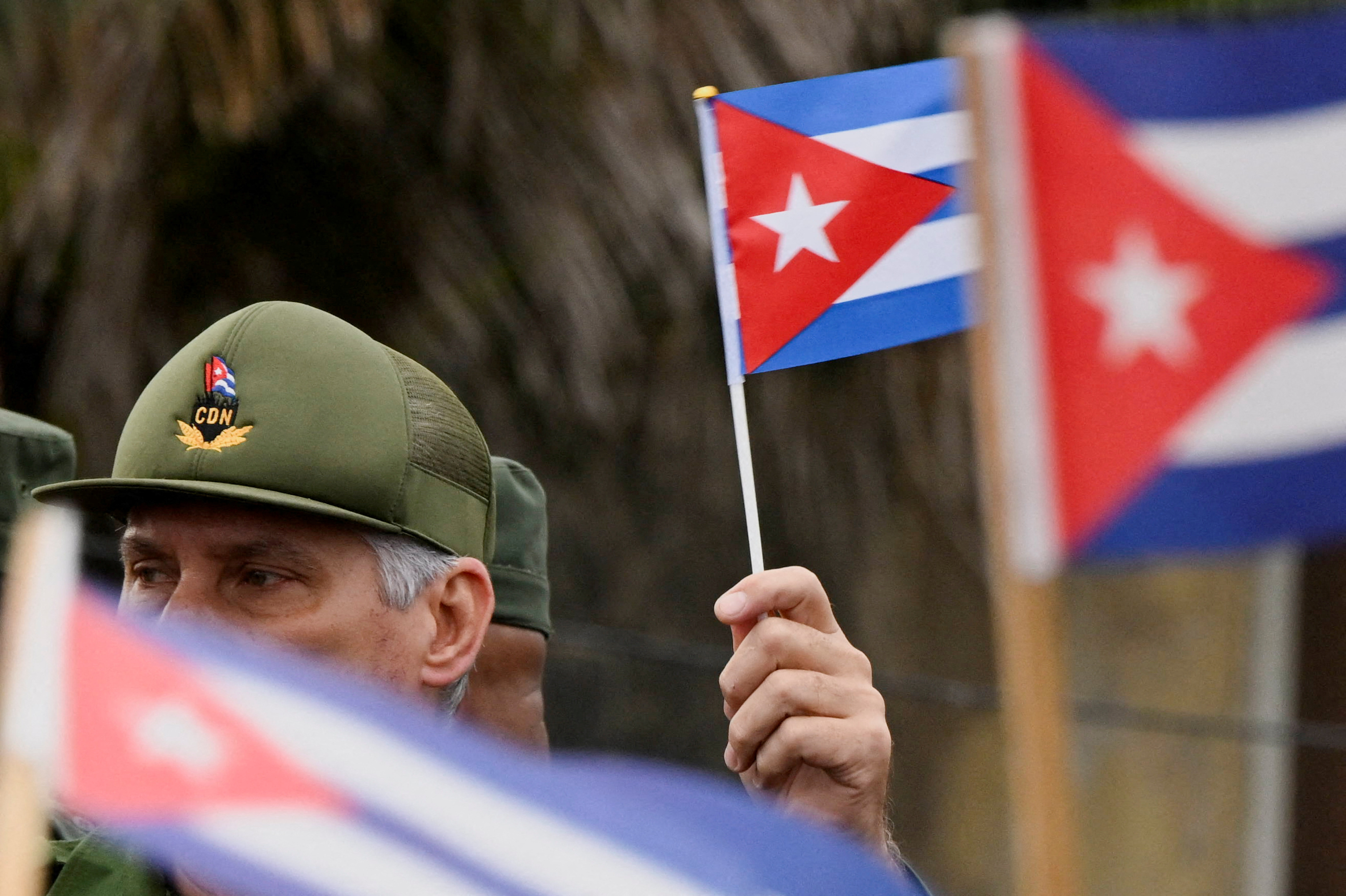 Cuban president holds a miniature Cuban flag at a protest