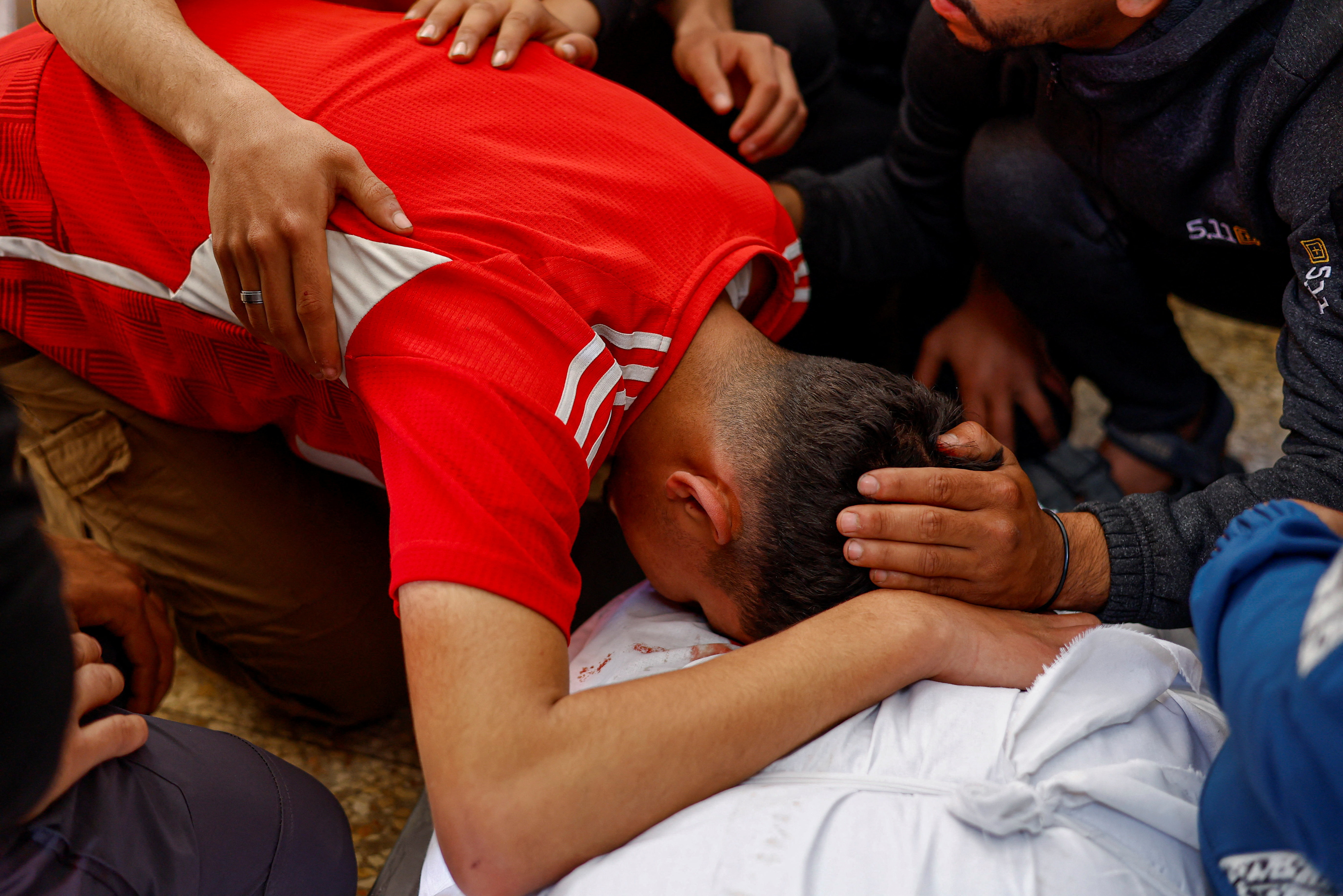 A mourner leans over the body of Palestinian Majdi Aslan, killed by Israeli gunfire, according to medics, at Al-Aqsa Martyrs Hospital in Deir al-Balah in the central Gaza Strip, April 6, 2026. REUTERS/Mahmoud Issa
