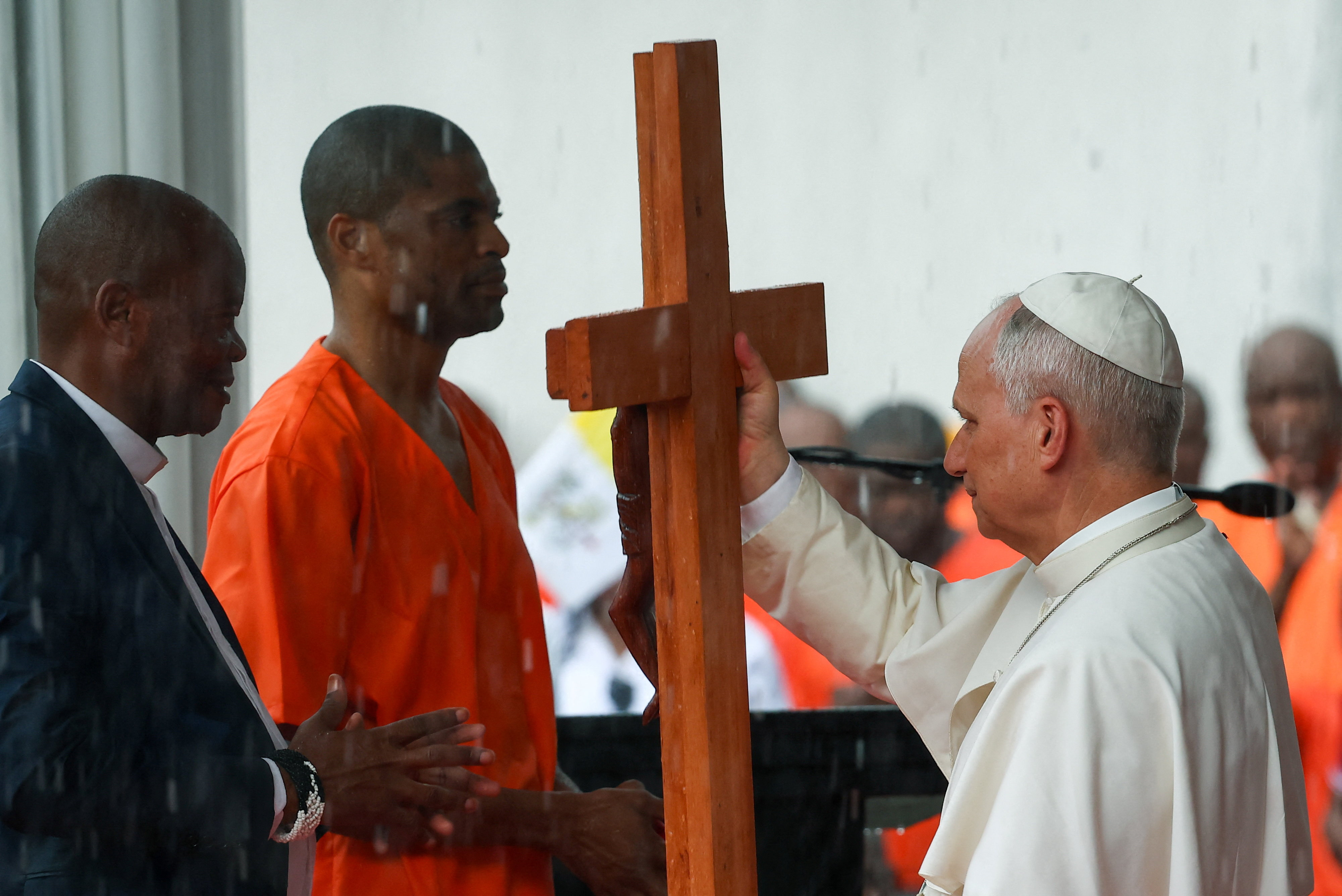Pope Leo XIV receives a cross from an inmate during the pope's visit at the Bata prison in Bata, Equatorial Guinea, April 22, 2026. REUTERS/Guglielmo Mangiapane