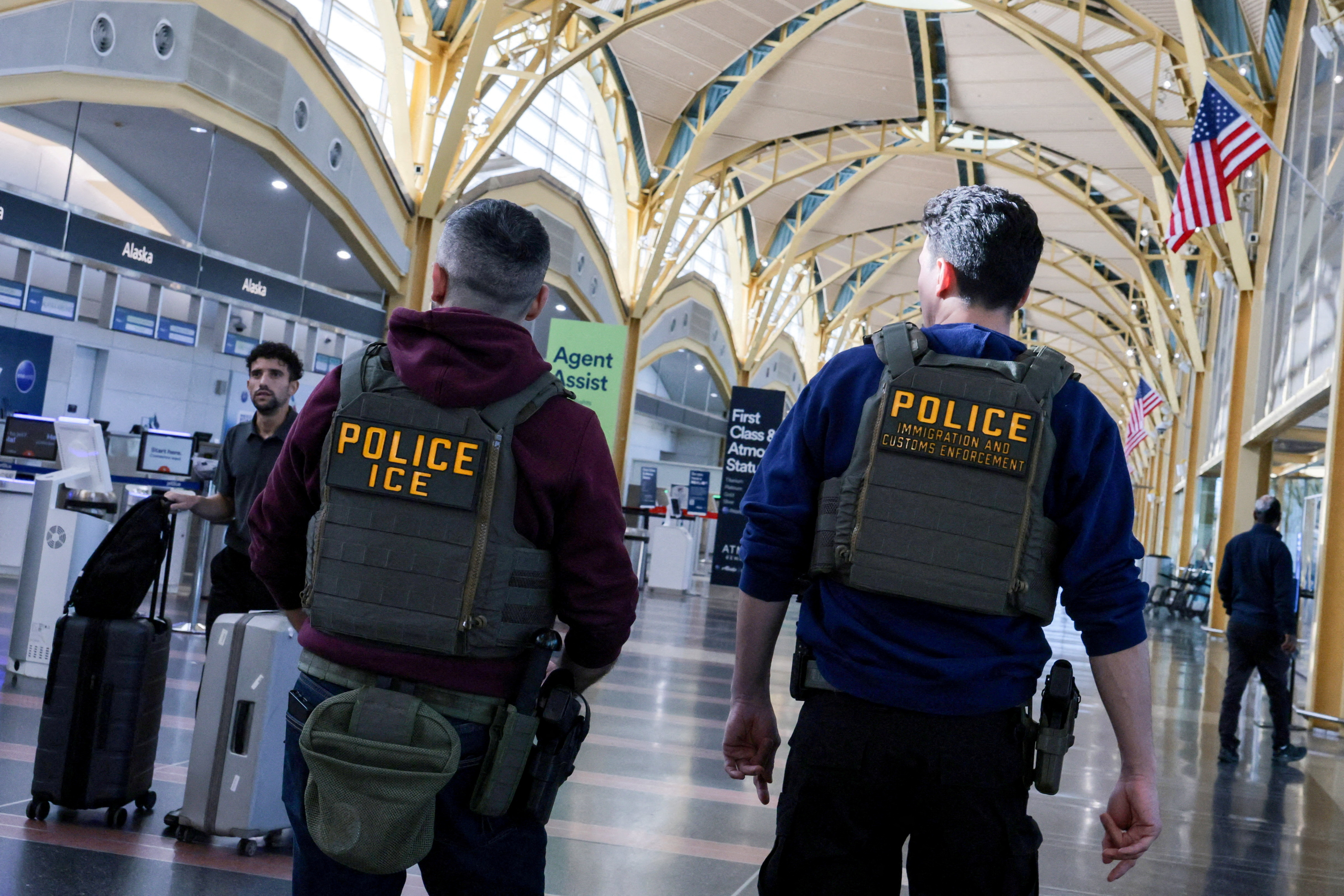 US Immigration and Customs Enforcement (ICE) agents patrol at an airport.