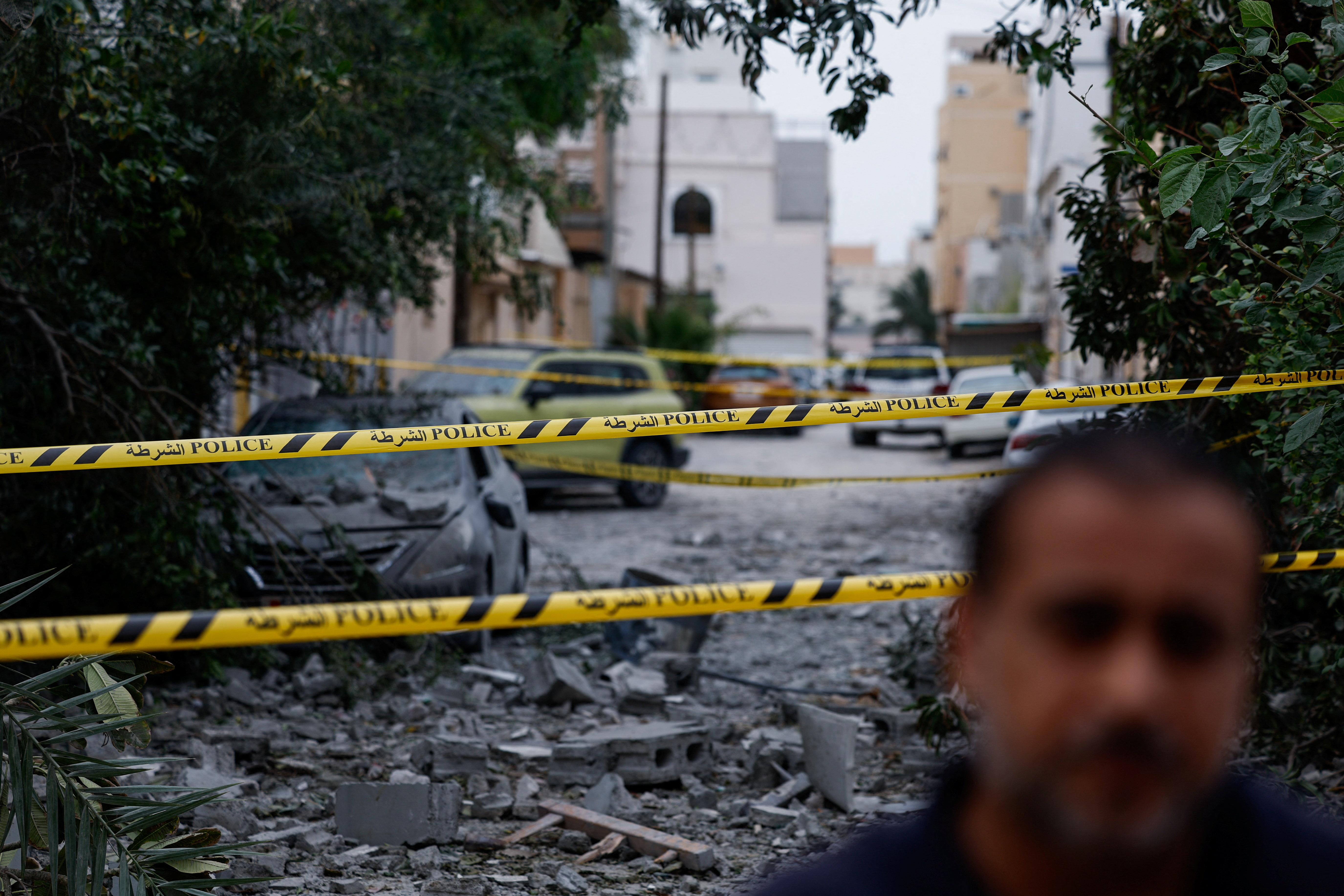 A wrecked car near damaged buildings at the site of an impact of what Bahrain's Ministry of Interior (MOI) said was falling debris of an intercepted Iranian drone