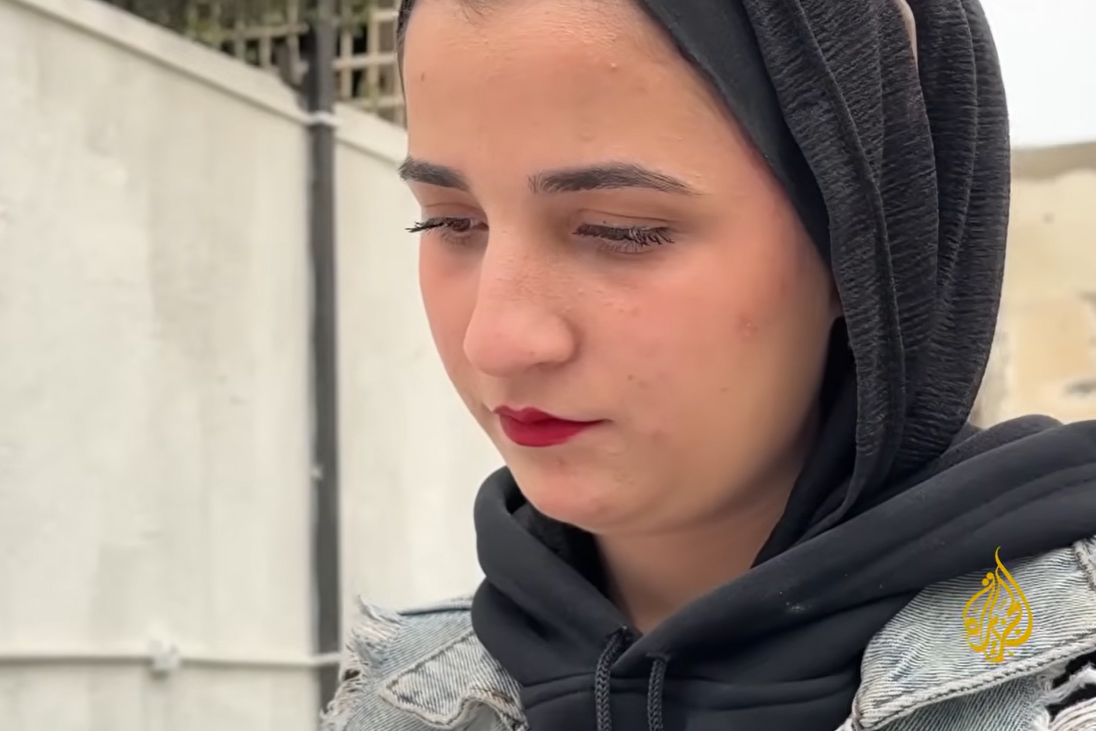 Mona Al-Mashharawi was scheduled to travel to Algeria for her university studies, but the war and sealed borders have kept her trapped in Gaza for over two years. [Screengrab/Al Jazeera]