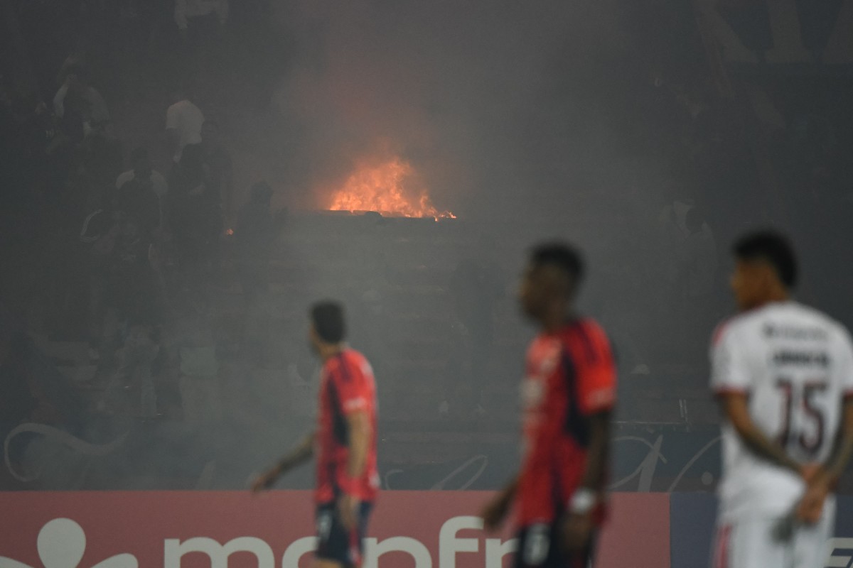 Medellin fans set fire in the stands during the Copa Libertadores group stage football match between Colombia's Independiente Medellin and Brazil's Flamengo