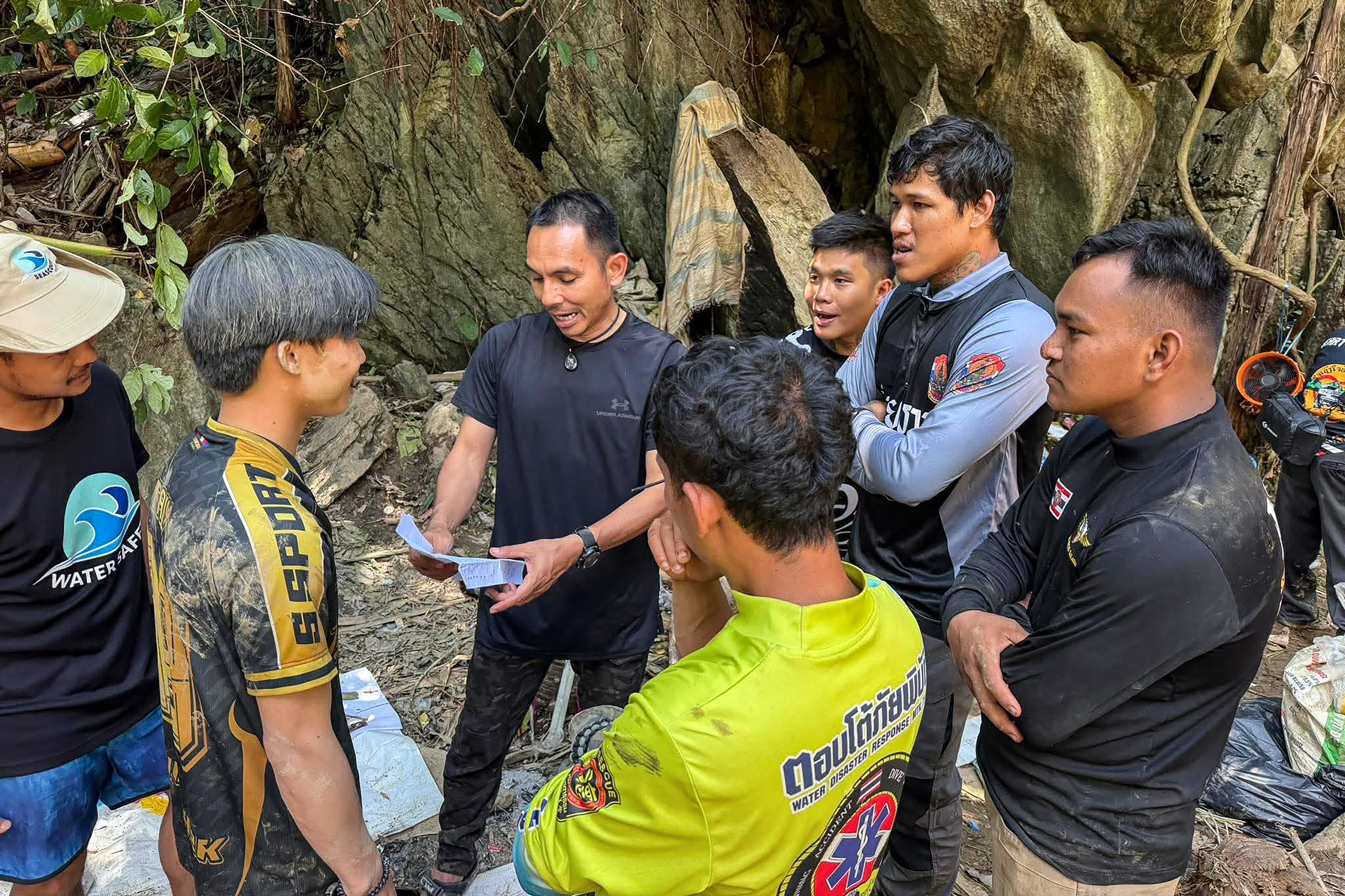 This handout image released by Metta Tham Rescue Kalasin on May 26, 2026 shows rescue workers speaking outside a cave in Xaisomboun province.