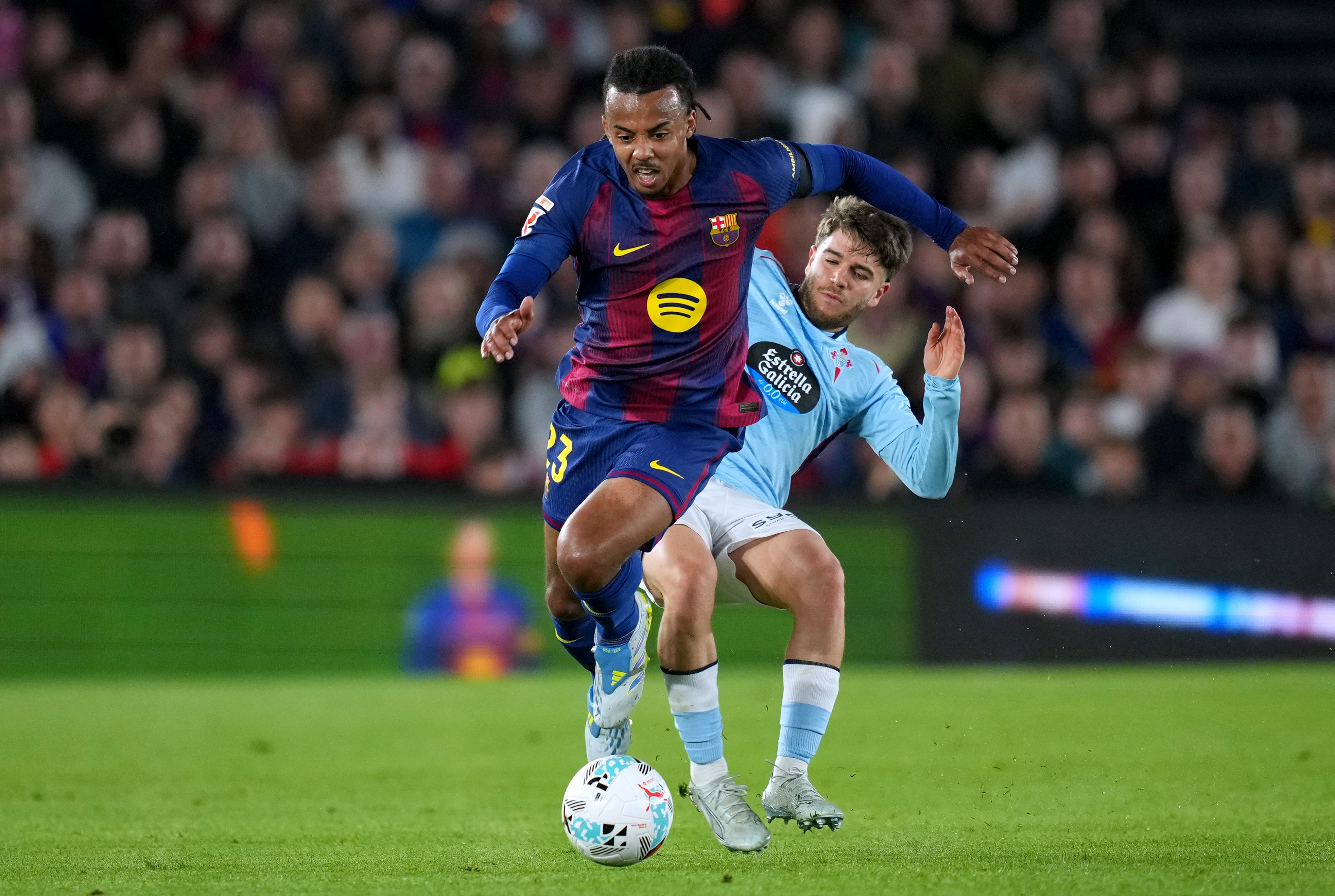 BARCELONA, SPAIN - APRIL 22: Jules Kounde of FC Barcelona runs with the ball under pressure from Sergio Carreira of Celta Vigo during the LaLiga EA Sports match between FC Barcelona and RC Celta de Vigo at Spotify Camp Nou on April 22, 2026 in Barcelona, Spain. (Photo by Alex Caparros/Getty Images)