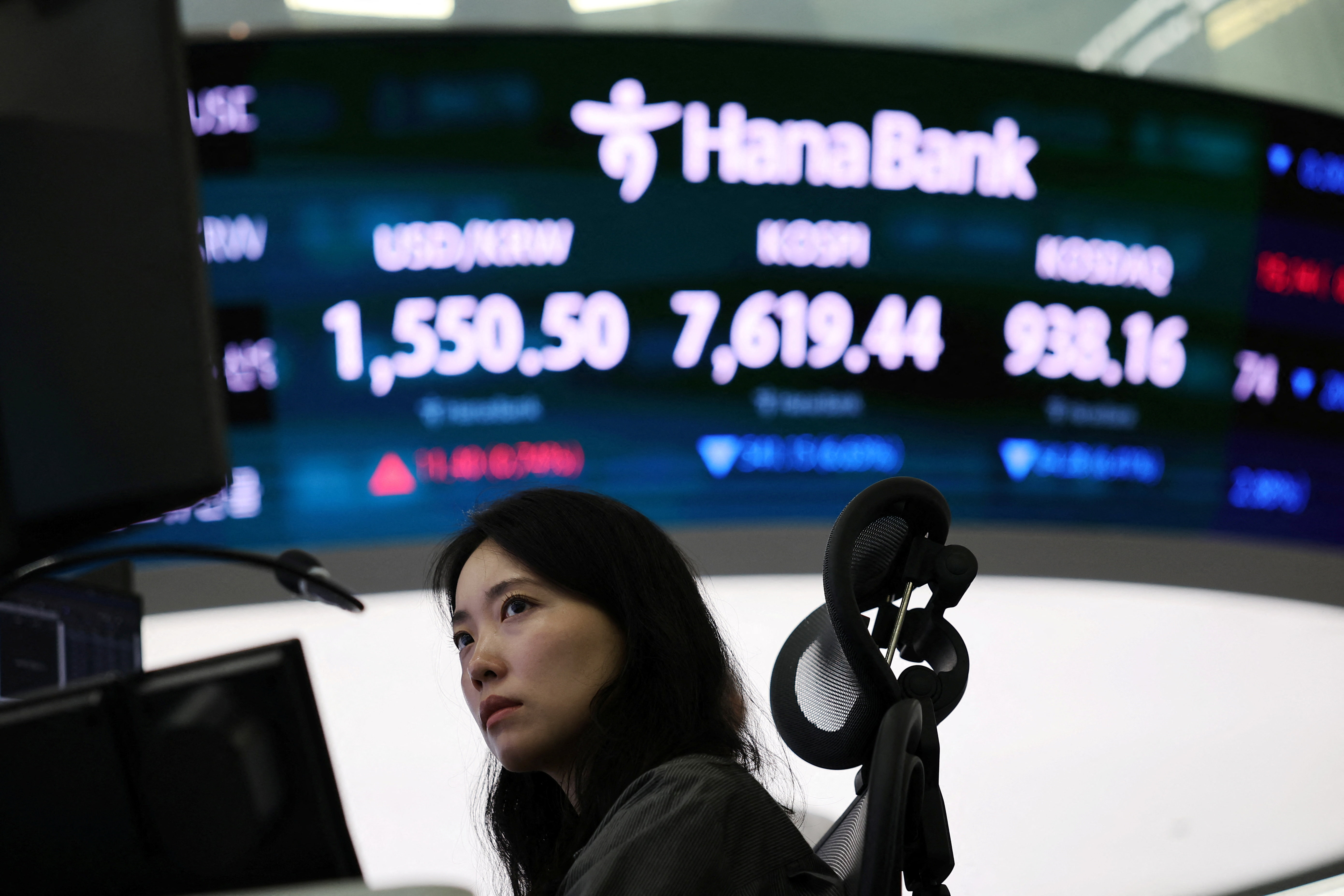A currency dealer works in front of an electronic board displaying the Kospi and currency exchanges rates at the dealing room of a bank in Seoul, South Korea, on June 8, 2026